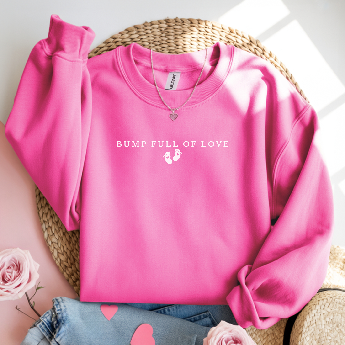 Pink sweatshirt with 'Bump Full of Love' text on a woven surface.