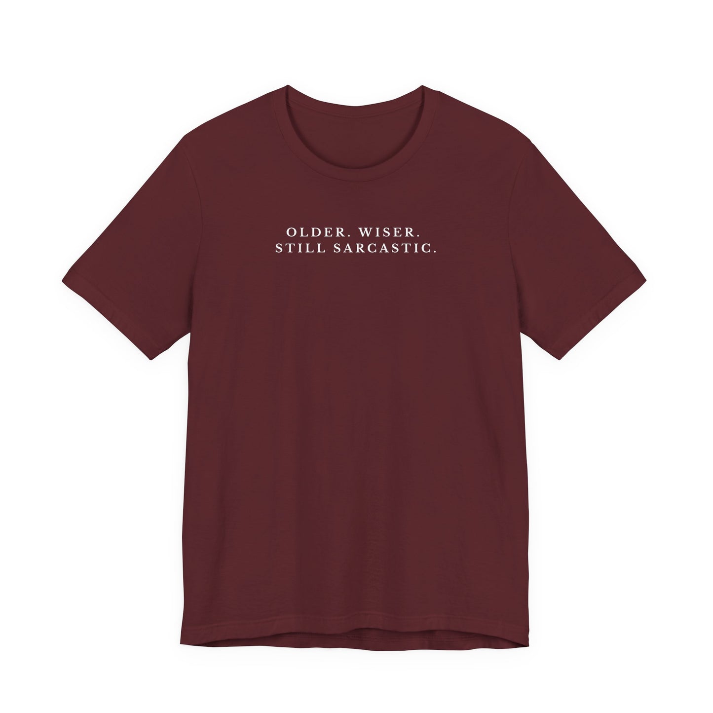 Maroon t-shirt with white text saying "older. wiser. still sarcastic." on a white background