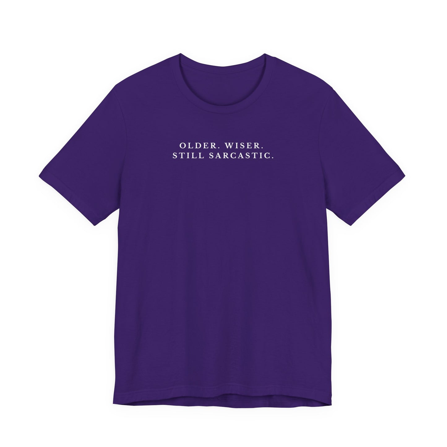 Purple t-shirt with white text saying "older. wiser. still sarcastic." on a white background
