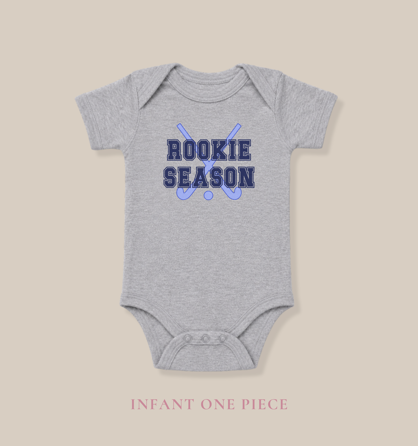 Bella + Canvas 100B athletic heather infant bodysuit featuring crossed field hockey sticks and "Rookie Season" text. Cute field hockey baby outfit for game days, field hockey families, baby showers, newborn photos, and celebrating baby's first field hockey season.