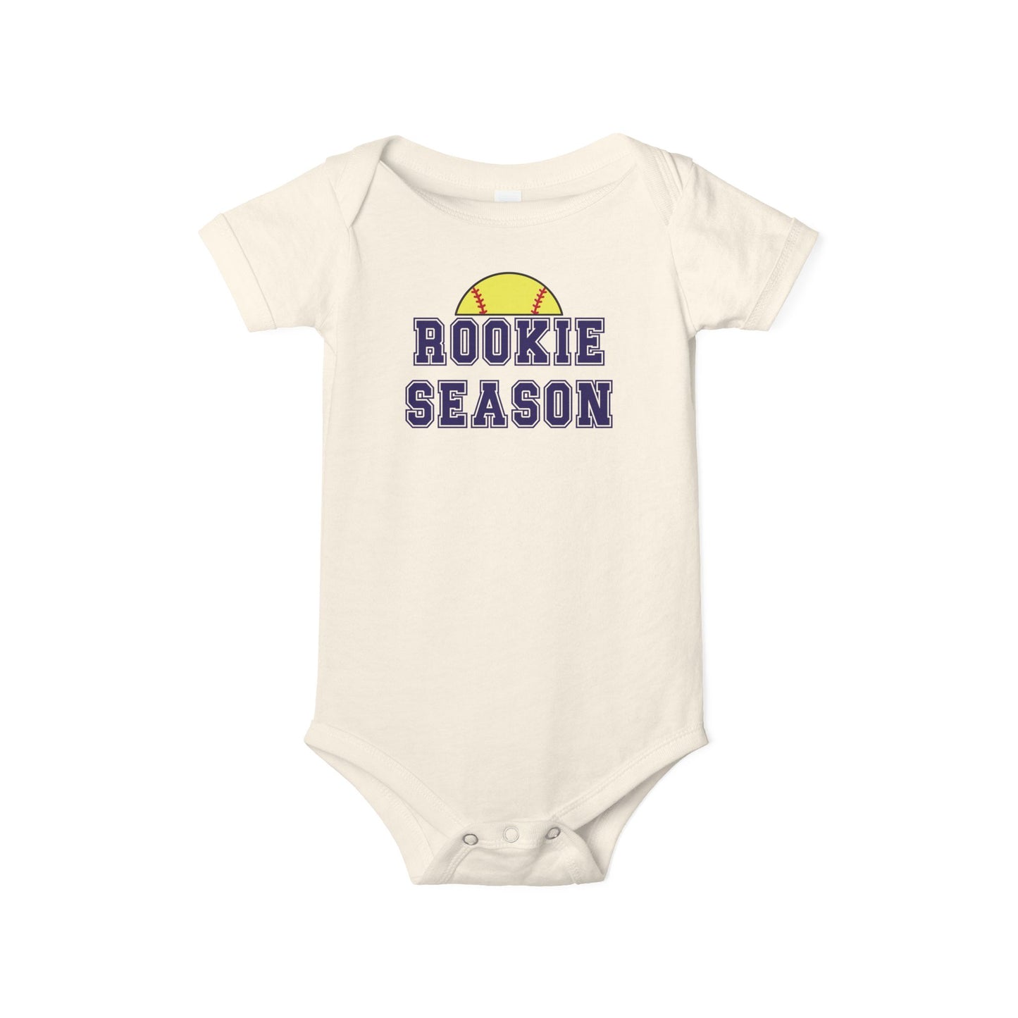 Bella + Canvas 100B natural infant bodysuit featuring a yellow softball graphic and "Rookie Season" text. Cute softball baby outfit perfect for softball season, game days, newborn photos, baby showers, and future softball fans.