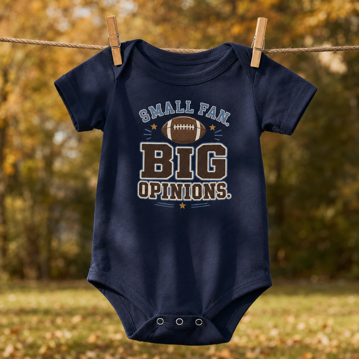 Bella + Canvas 100B infant one piece in Navy featuring a football graphic and the phrase "Small Fan. Big Opinions." Soft football-themed baby bodysuit perfect for newborns, infants, football season, game days, tailgates, baby showers, and sports-loving families.