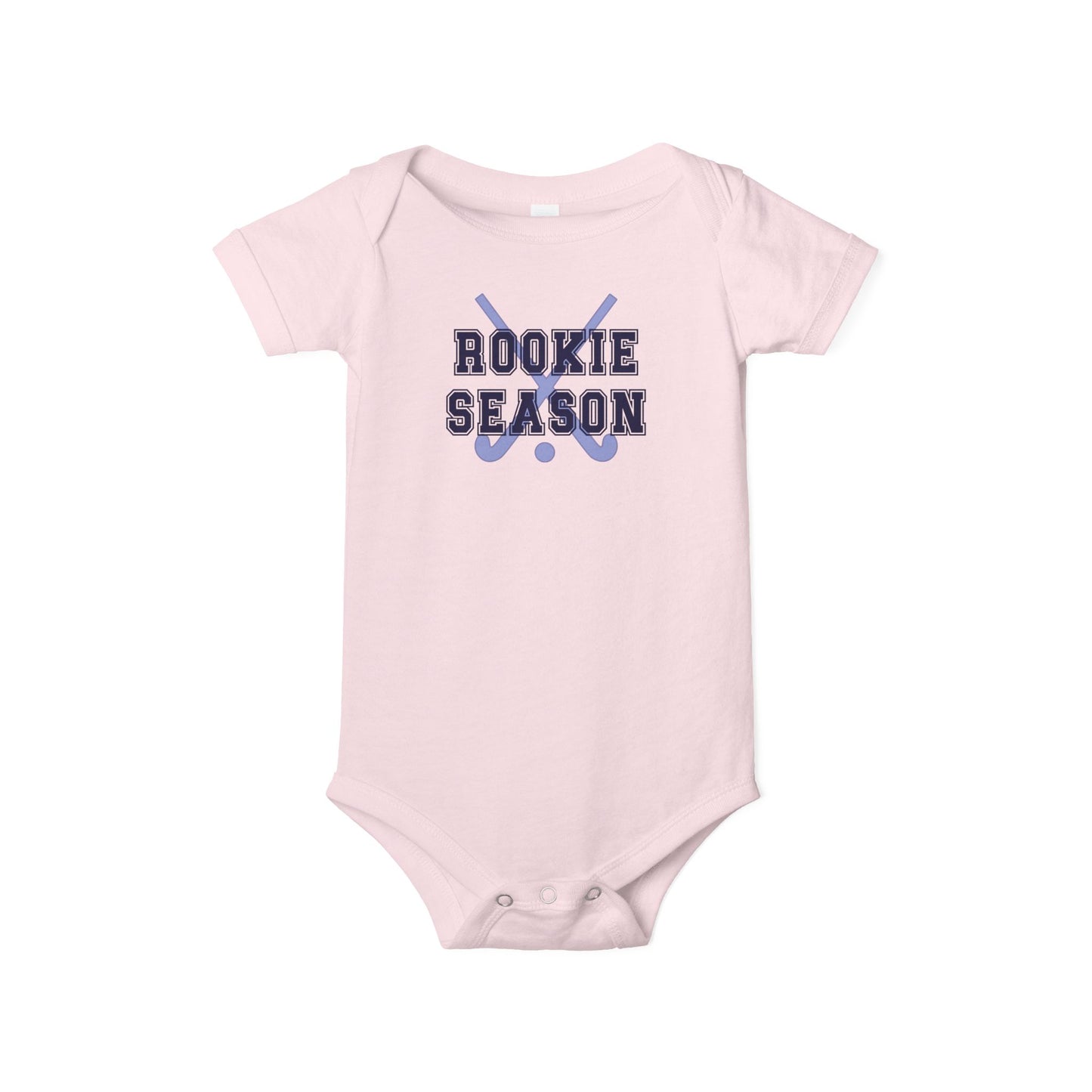 Bella + Canvas 100B pink infant bodysuit featuring crossed field hockey sticks and "Rookie Season" text. Soft pink baby one-piece for field hockey families, baby girls, newborn gifts, game day outfits, and celebrating a baby's first field hockey season.