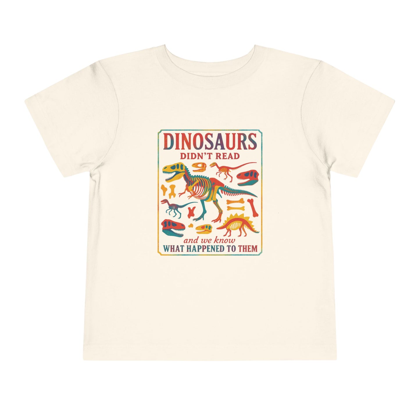 Bella + Canvas 3001T toddler t-shirt in natural featuring a colorful dinosaur skeleton graphic and the funny reading quote “Dinosaurs Didn’t Read and We Know What Happened to Them.” Educational dinosaur shirt for toddlers, perfect for school, library visits, and young book lovers.