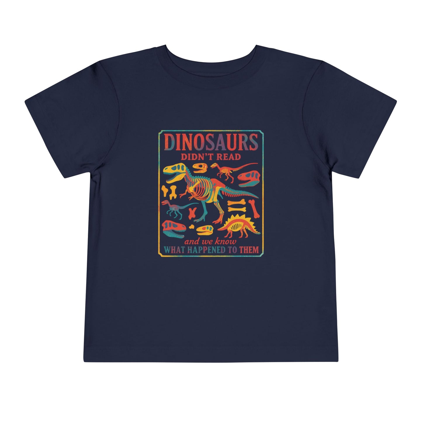 Bella + Canvas 3001T toddler t-shirt in navy featuring a colorful dinosaur skeleton graphic and the humorous quote “Dinosaurs Didn’t Read and We Know What Happened to Them.” Funny dinosaur book lover shirt for toddlers, perfect for preschool, kindergarten, library days, and back-to-school outfits.