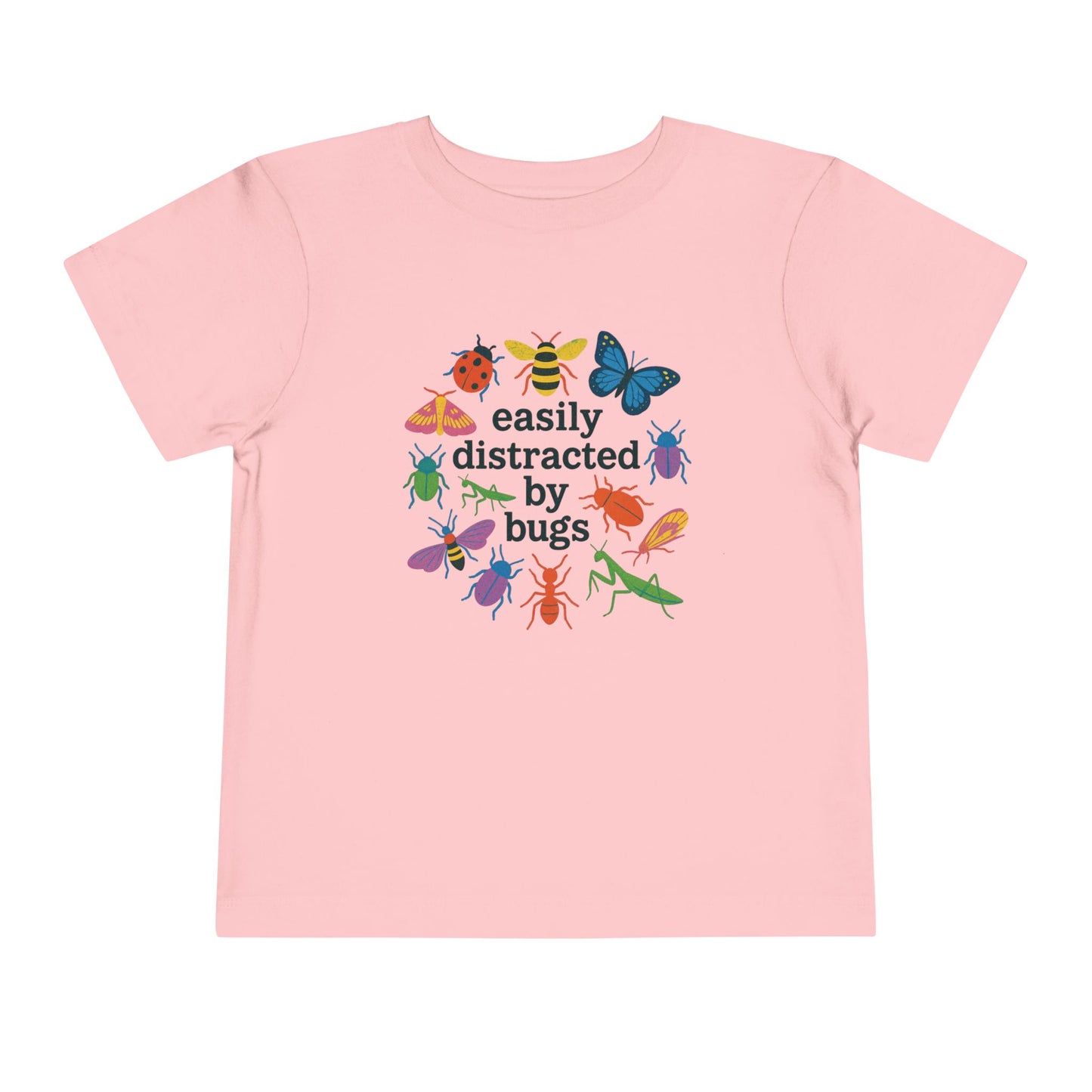 Bella + Canvas 3001T toddler t-shirt in pink featuring colorful butterflies, bees, beetles, ladybugs, and praying mantises surrounding the phrase “Easily Distracted by Bugs.” Cute insect lover shirt for toddlers who enjoy bugs, nature, science, gardening, outdoor play, and exploring the world around them.