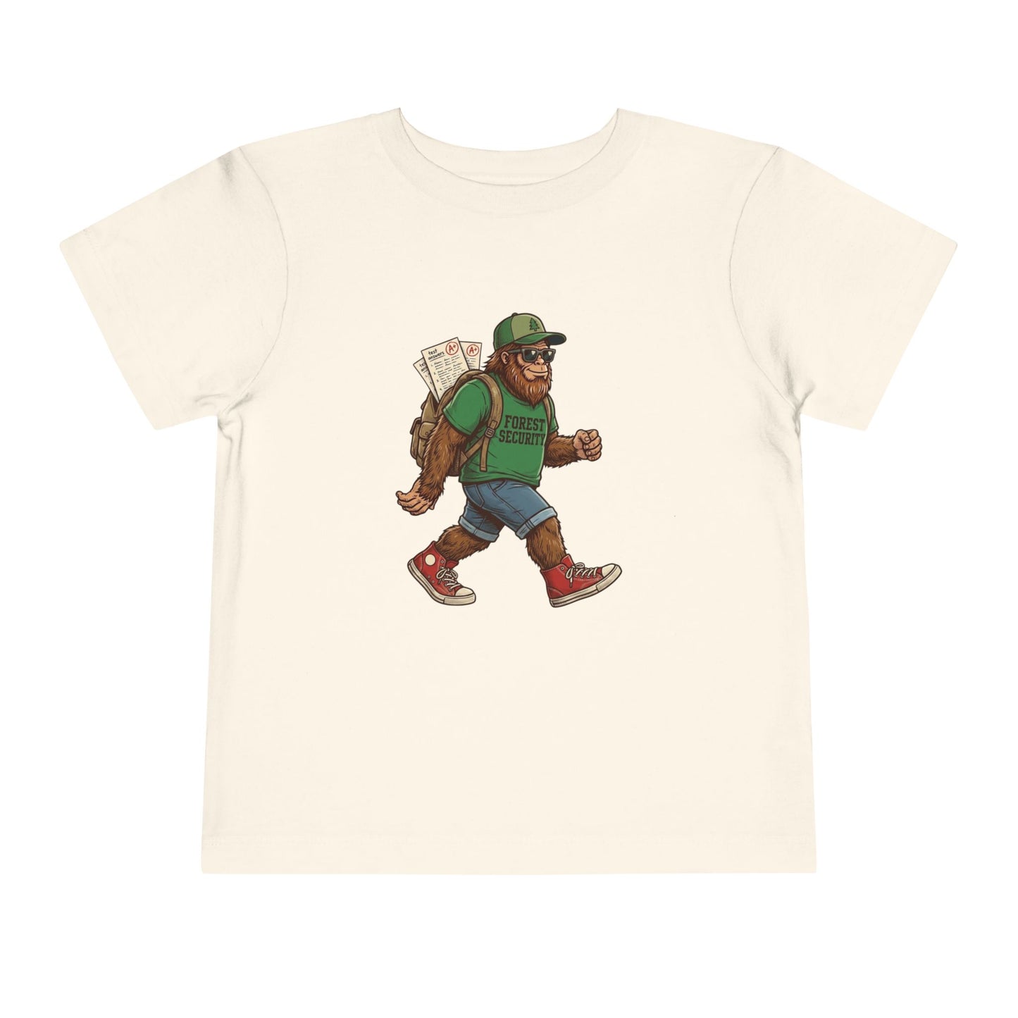 Bella + Canvas 3001T toddler t-shirt in natural featuring a walking Bigfoot student graphic wearing sunglasses, a green Forest Security shirt, backpack with school papers, denim shorts, and red sneakers on a clean white background.