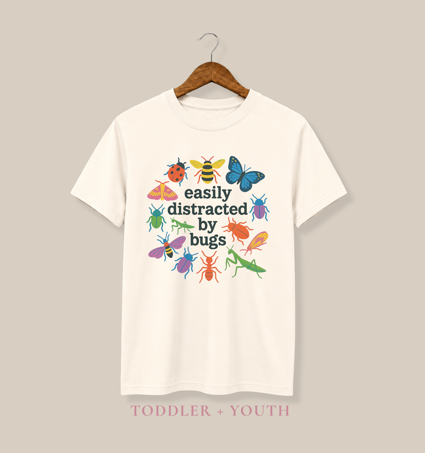 Bella + Canvas 3001Y youth t-shirt in natural featuring colorful insects, butterflies, bees, beetles, and praying mantises surrounding the phrase “Easily Distracted by Bugs.” Fun nature-themed shirt for kids who love bugs, insects, science, outdoor adventures, and exploring the natural world.