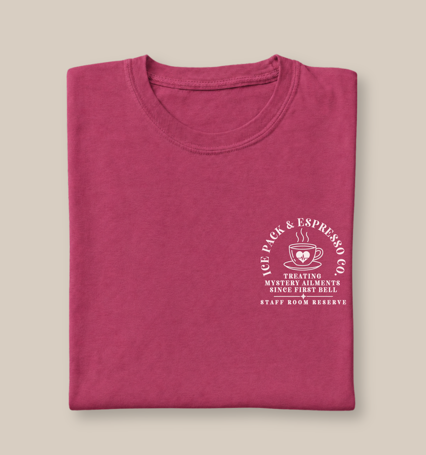 Bella + Canvas 3001 unisex t-shirt in Berry featuring a white Ice Pack & Espresso Co. pocket-style graphic with a steaming coffee cup and heart icon. The design reads "Treating Mystery Ailments Since First Bell" and "Staff Room Reserve," making it a fun graphic tee for school nurses, healthcare professionals, and coffee lovers.