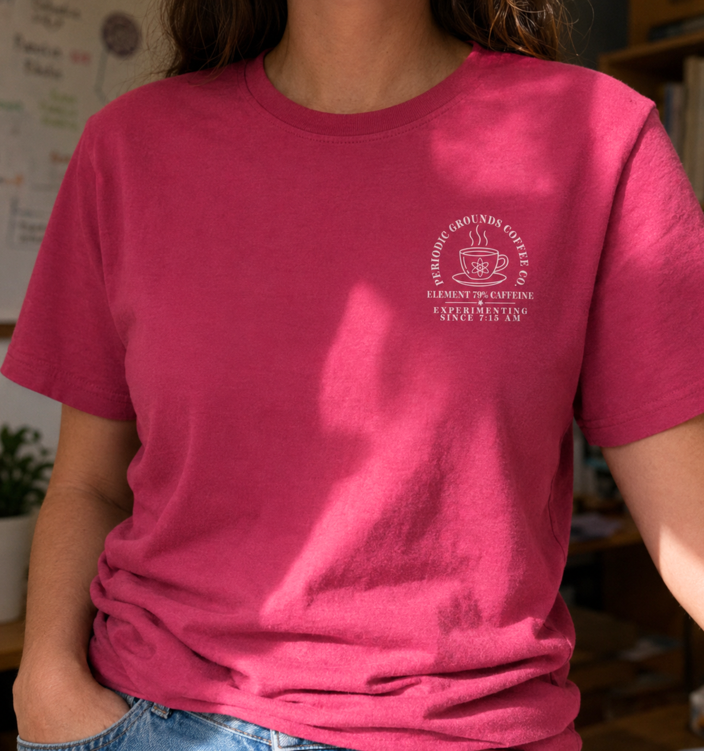 Bella + Canvas 3001 unisex t-shirt in Berry featuring a white Periodic Grounds Coffee Co. pocket design with a steaming coffee mug, atom symbol, and the phrases "Element 79% Caffeine" and "Experimenting Since 7:15 AM." A fun science teacher shirt for chemistry teachers, STEM educators, and coffee lovers.