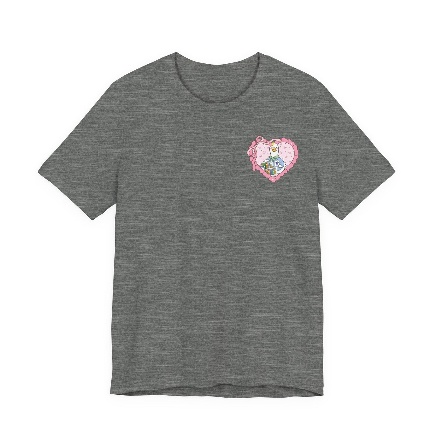 Bella + Canvas 3001 t-shirt in Deep Heather featuring a coquette school librarian goose pocket design. The artwork shows a white goose behind a colorful library cart inside a pink heart with ribbon details. Fun reading-themed shirt for librarians and book lovers.