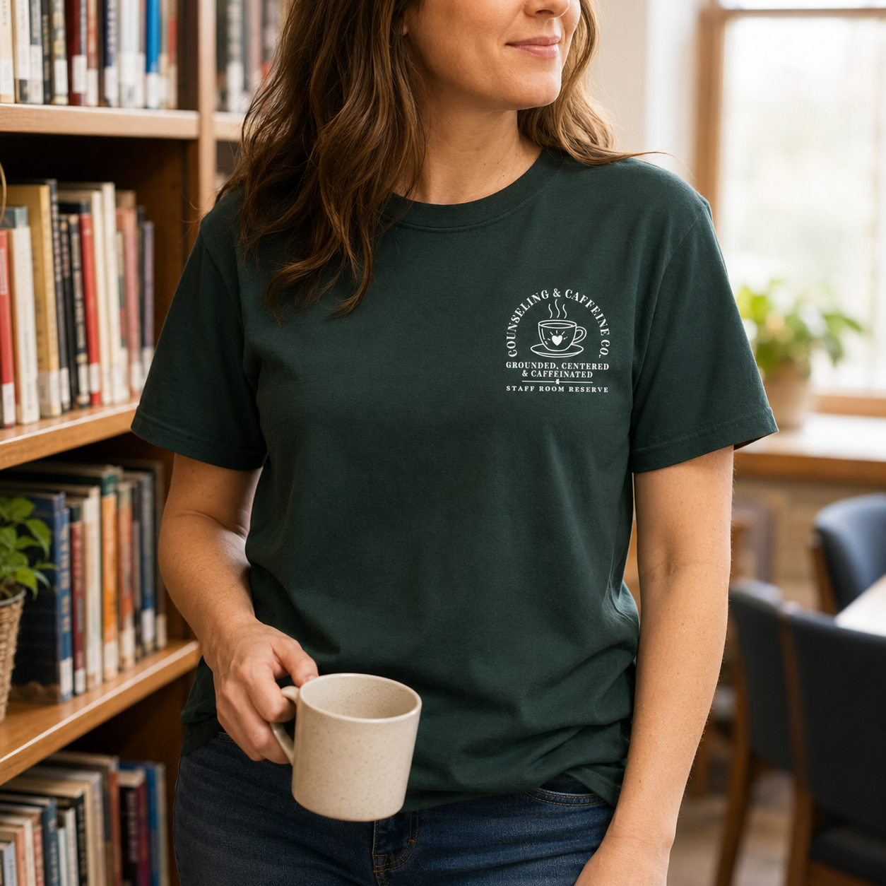 Bella + Canvas 3001 unisex t-shirt in Forest featuring a small left chest "Counseling & Caffeine Co." coffee-themed graphic with the phrases "Grounded, Centered & Caffeinated" and "Staff Room Reserve." A cozy counselor-inspired graphic tee perfect for school counselors, guidance counselors, therapists, and everyday casual wear.