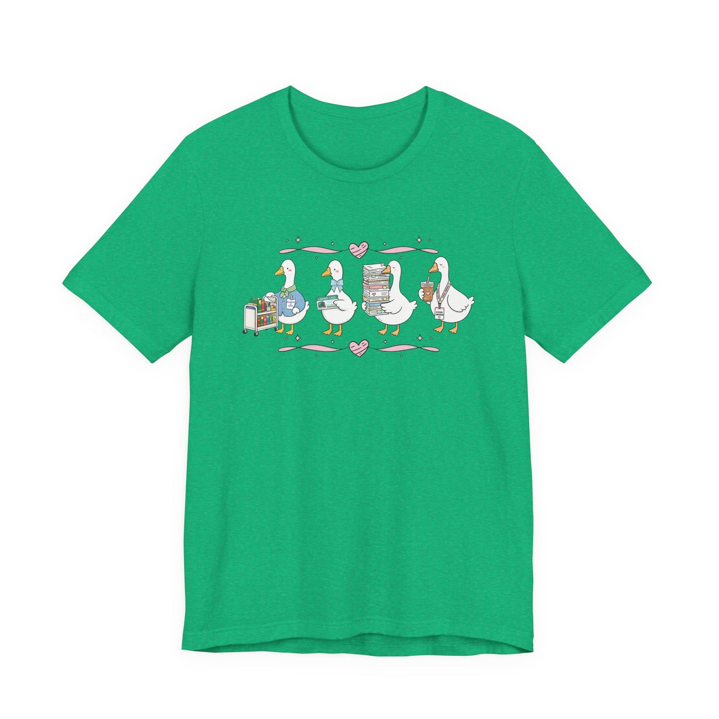 Bella + Canvas 3001 t-shirt in Heather Kelly featuring a coquette librarian goose design. Four white geese showcase a book cart, library card, stack of books, and iced coffee with a school librarian badge. Pink hearts and ribbon accents create a charming bookish aesthetic, making this librarian shirt perfect for school librarians, media specialists, library staff, book lovers, teacher appreciation gifts, and back-to-school wear.