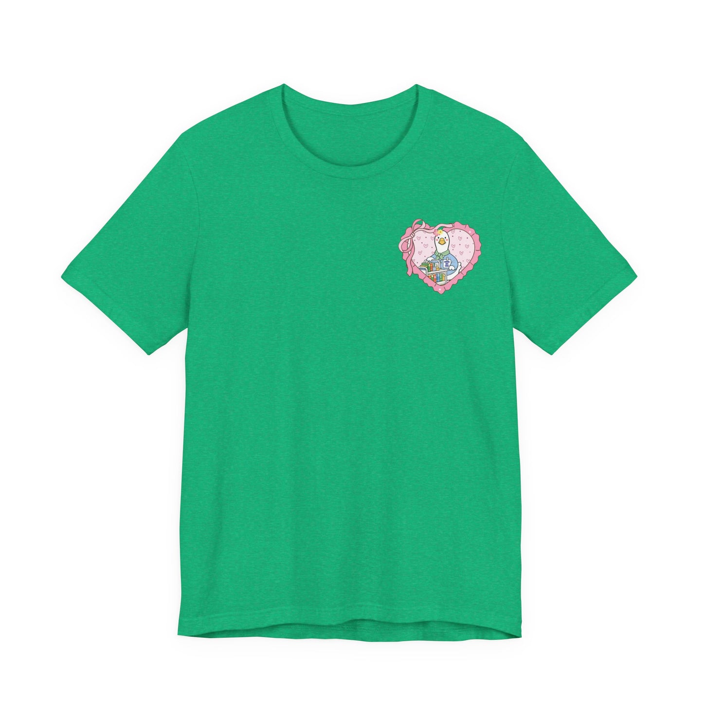 Bella + Canvas 3001 t-shirt in Heather Kelly featuring a coquette school librarian goose pocket design. The artwork shows a white goose with a book cart inside a pink heart pocket graphic. Fun librarian shirt for media specialists, teachers, and book lovers.