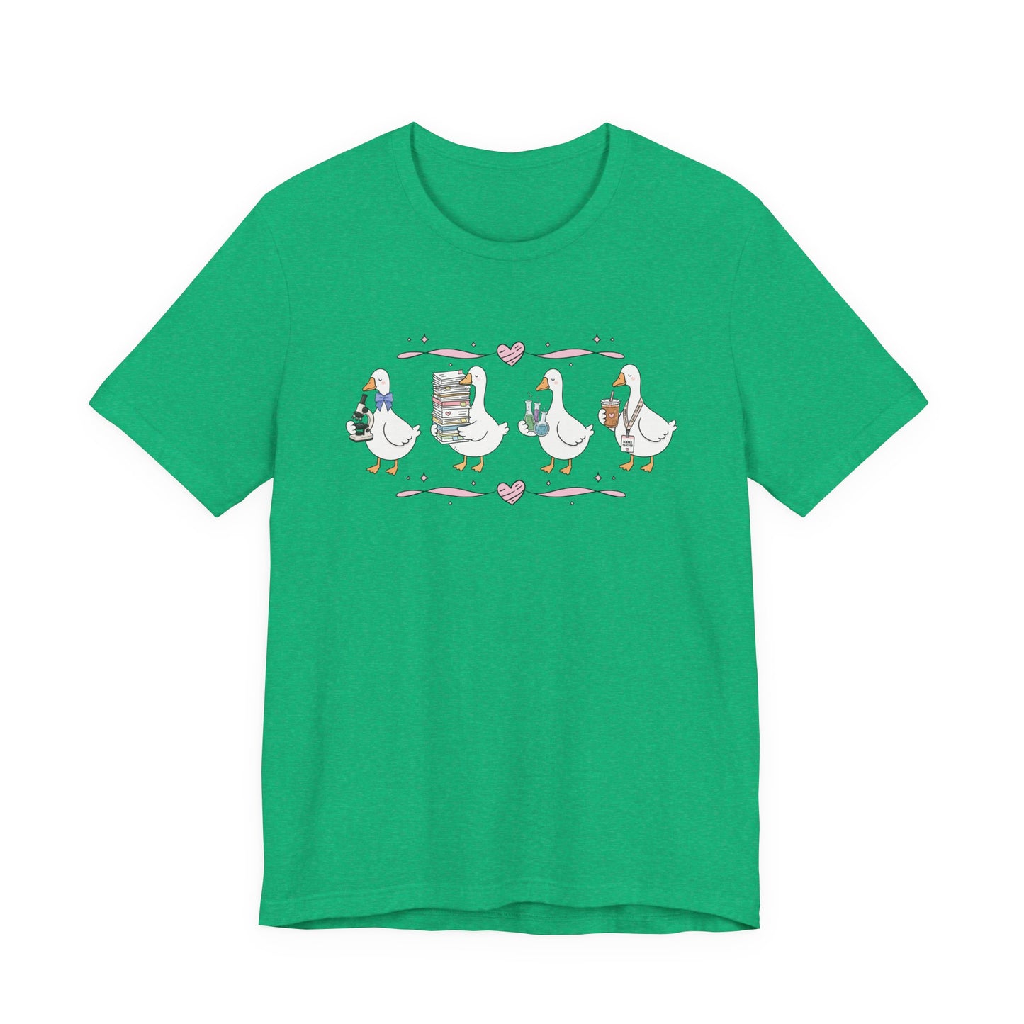 Bella + Canvas 3001 t-shirt in Heather Kelly featuring a coquette science teacher goose design. Four white geese hold a microscope, a stack of classroom papers, science beakers filled with colorful experiments, and an iced coffee with a science teacher lanyard. Pink hearts and ribbon accents add a charming touch, making this cute science teacher shirt perfect for back-to-school outfits, teacher appreciation gifts, and everyday classroom wear.