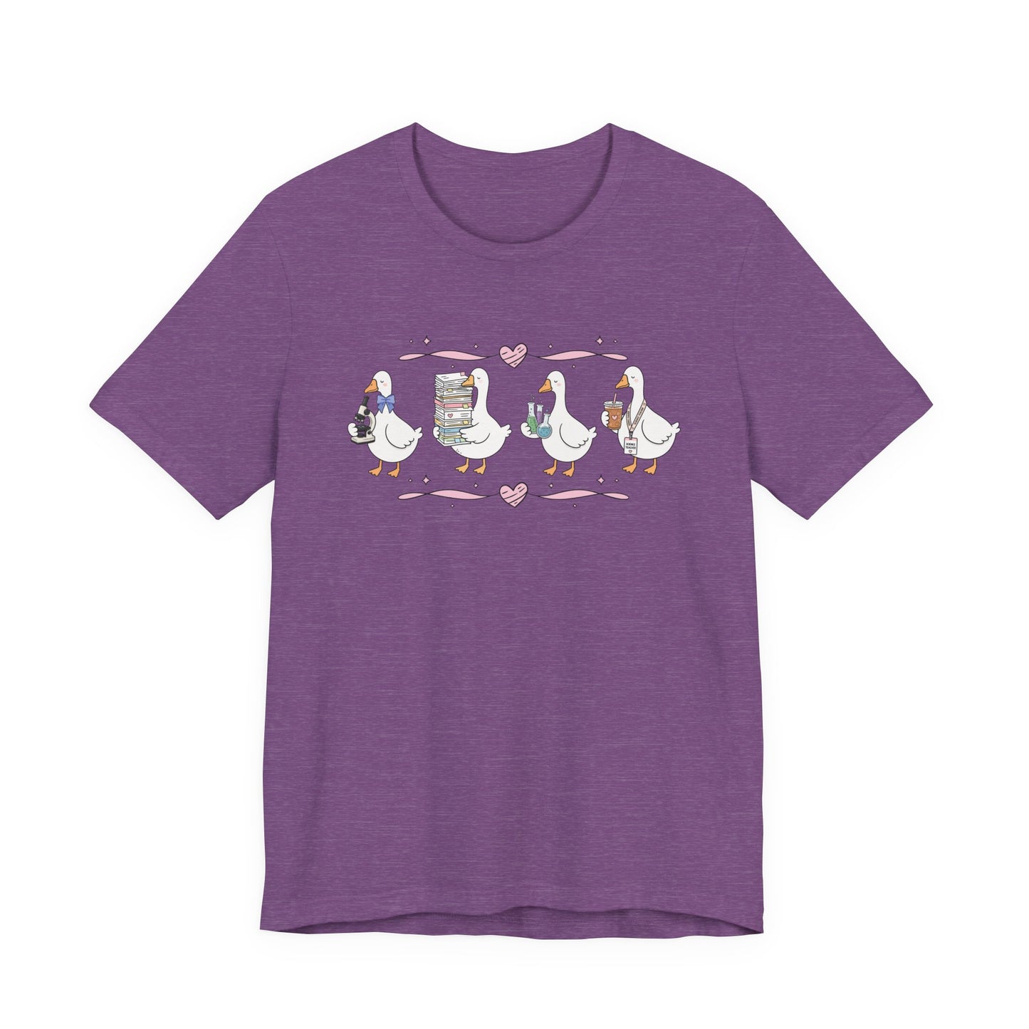 Bella + Canvas 3001 t-shirt in Heather Team Purple featuring a coquette science teacher goose design. Four white geese hold a microscope, a stack of classroom papers, science beakers filled with colorful experiments, and an iced coffee with a science teacher lanyard. Pink hearts and ribbon accents create a whimsical classroom-inspired look, making this cute science teacher shirt perfect for back-to-school outfits, teacher appreciation gifts, and everyday classroom wear.