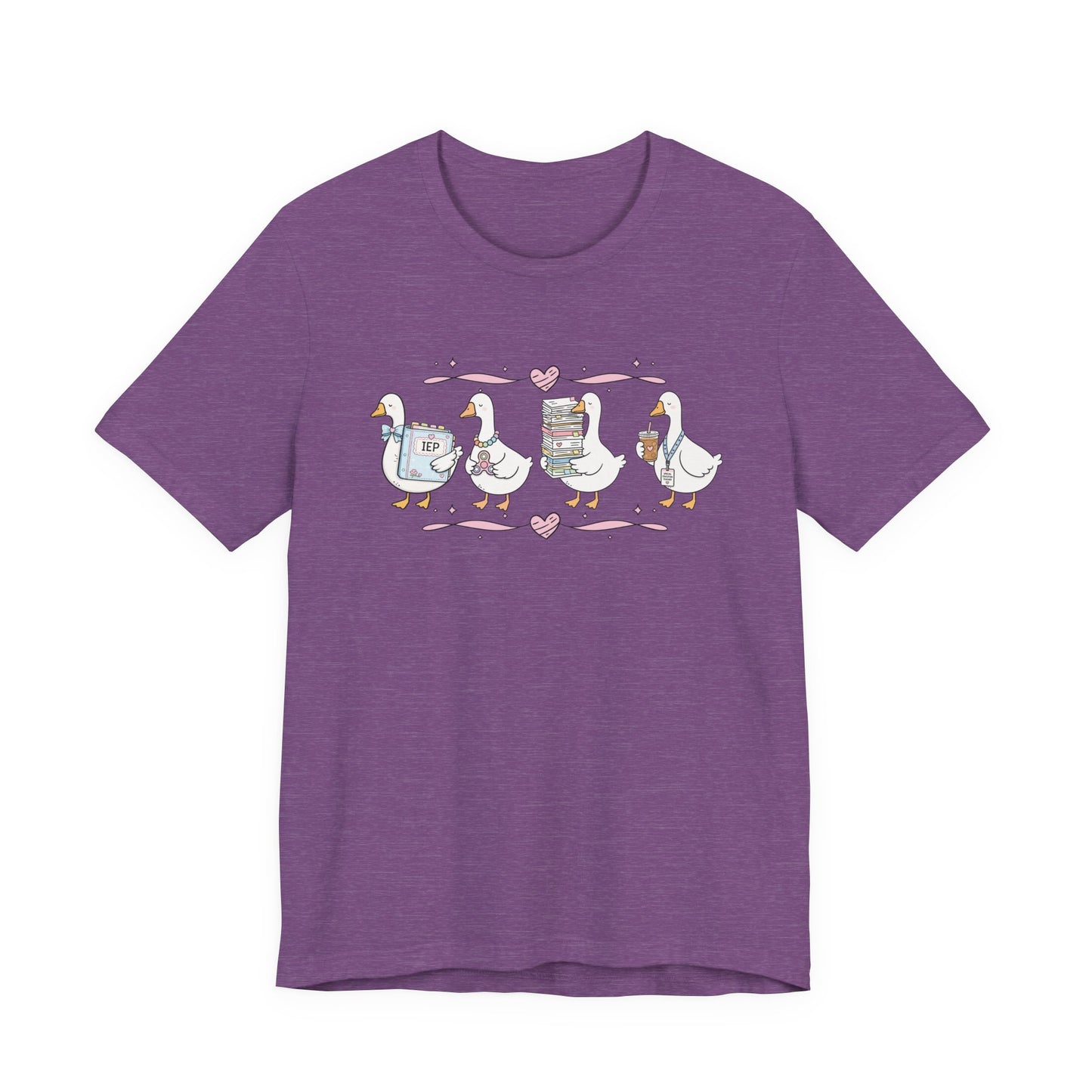 Bella + Canvas 3001 t-shirt in Heather Team Purple featuring a coquette special education teacher goose design. Four white geese hold an IEP binder, sensory fidget toy, stack of paperwork, and iced coffee with a special education teacher lanyard. Pink hearts and ribbon accents add a charming touch. This cute SPED teacher shirt is perfect for special education teachers, back-to-school outfits, teacher appreciation gifts, and everyday classroom wear.