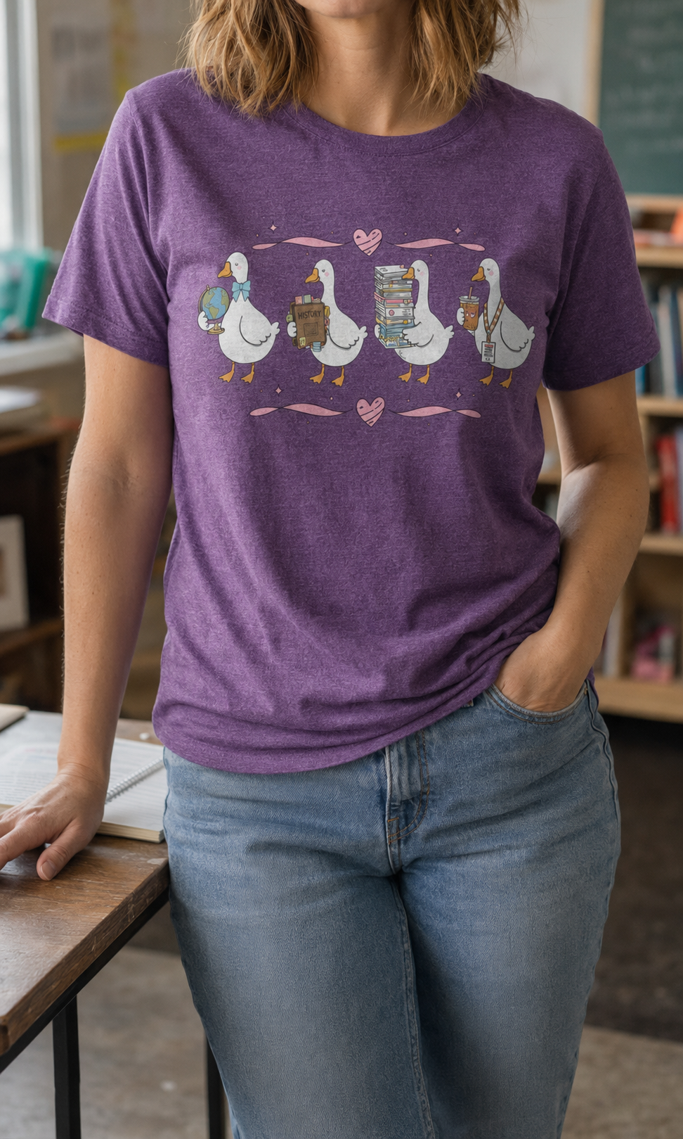 Bella + Canvas 3001 unisex t-shirt in Heather Team Purple featuring four adorable teacher geese carrying a globe, history book, stack of books, and iced coffee with a teacher badge. A cute world history teacher shirt perfect for history educators, social studies teachers, classroom wear, and back-to-school outfits.