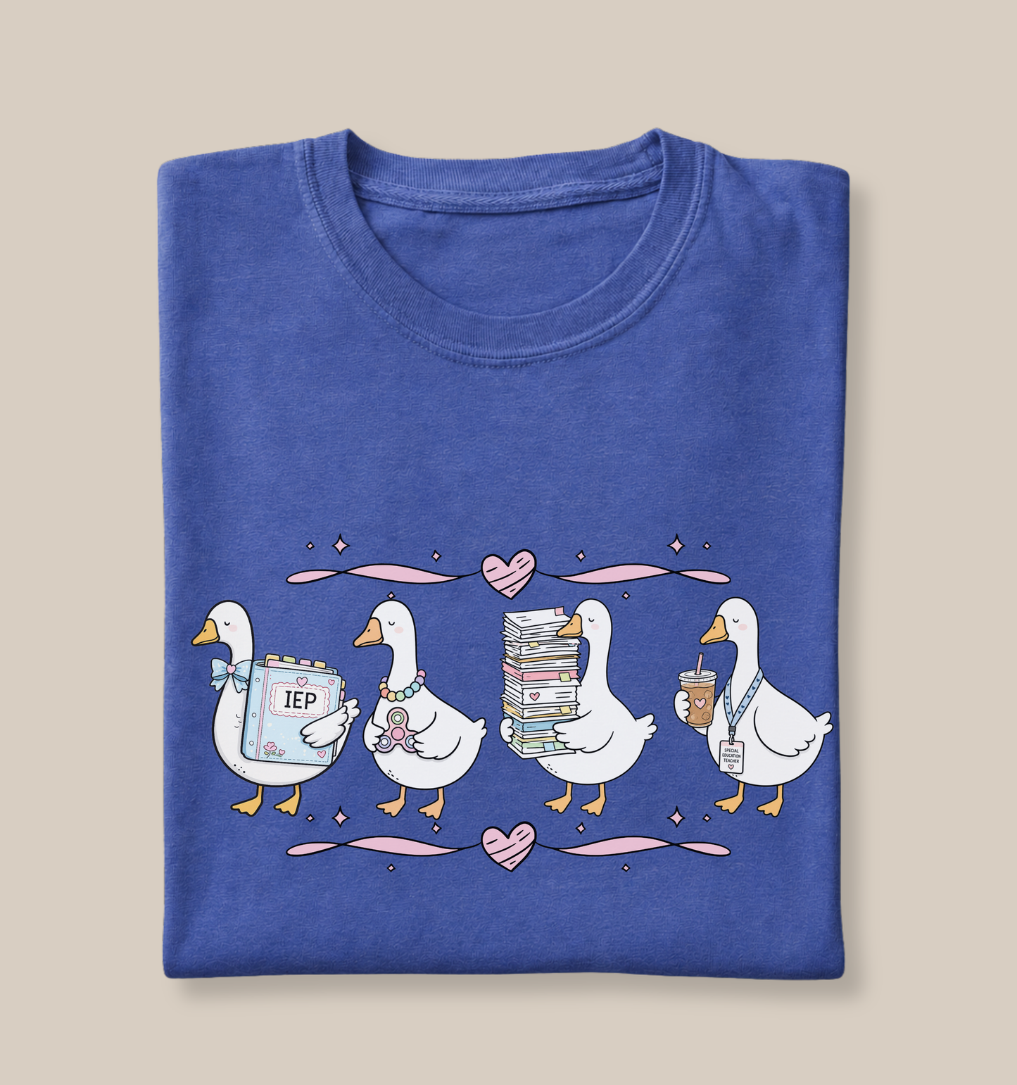 Bella + Canvas 3001 t-shirt in Heather True Royal featuring a coquette special education teacher goose design. Four white geese hold an IEP binder, sensory fidget toy, stack of paperwork, and iced coffee with a special education teacher lanyard. Pink hearts and ribbon accents add a charming touch. This cute SPED teacher shirt is perfect for special education teachers, back-to-school outfits, teacher appreciation gifts, and everyday classroom wear.