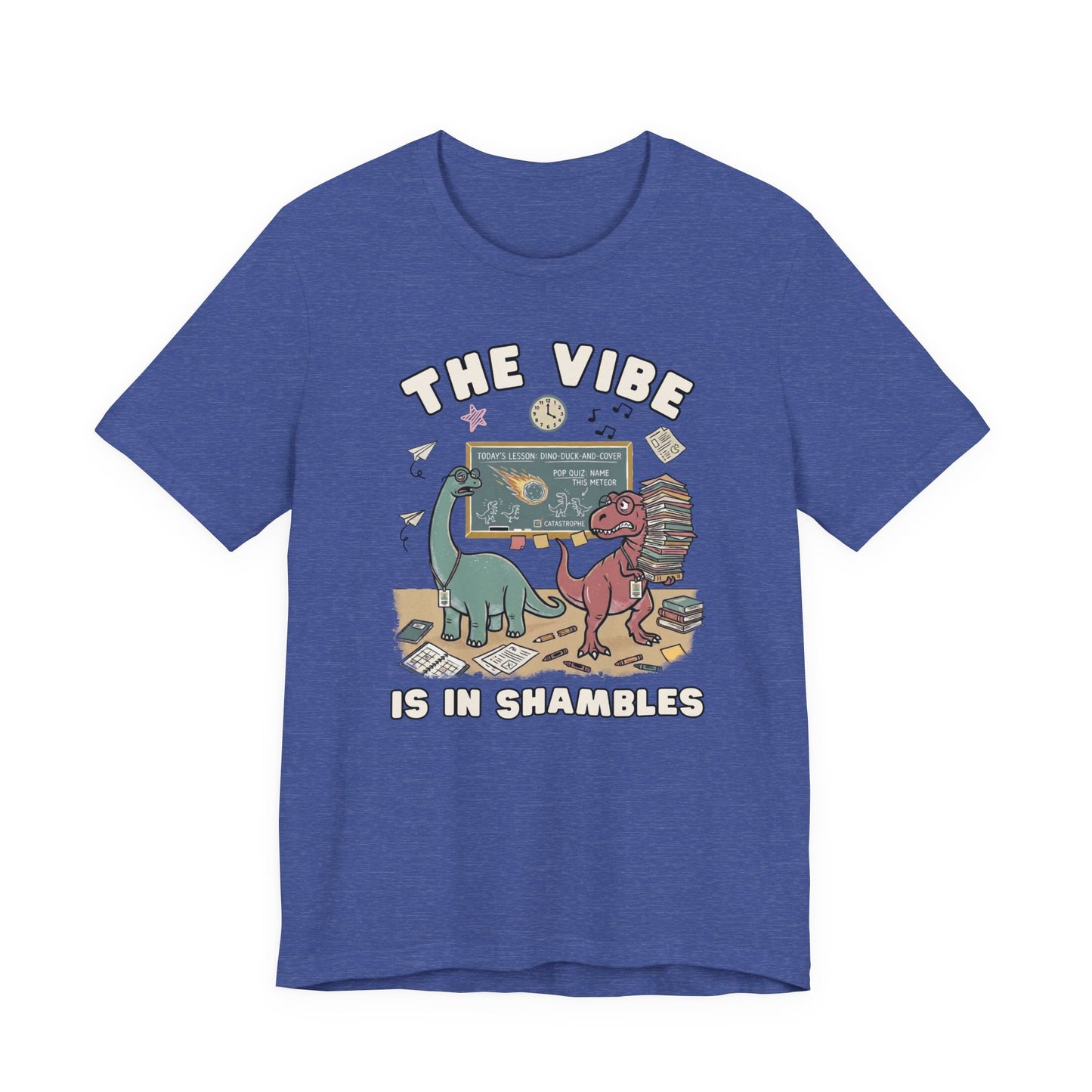 Bella + Canvas 3001 heather true royal blue teacher t-shirt featuring two overwhelmed dinosaurs in a messy classroom with books, papers, and a chalkboard. Funny teacher graphic tee with "The Vibe Is In Shambles" design, perfect for teachers, educators, back-to-school outfits, and teacher appreciation gifts.