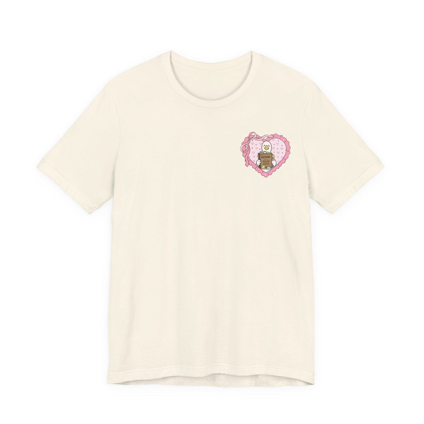 Bella + Canvas 3001 t-shirt in Natural featuring a coquette history teacher goose heart design on the left chest. White goose holding a history book inside a pink heart with bow accents. Perfect for history teachers, social studies educators, humanities teachers, and classroom wear.