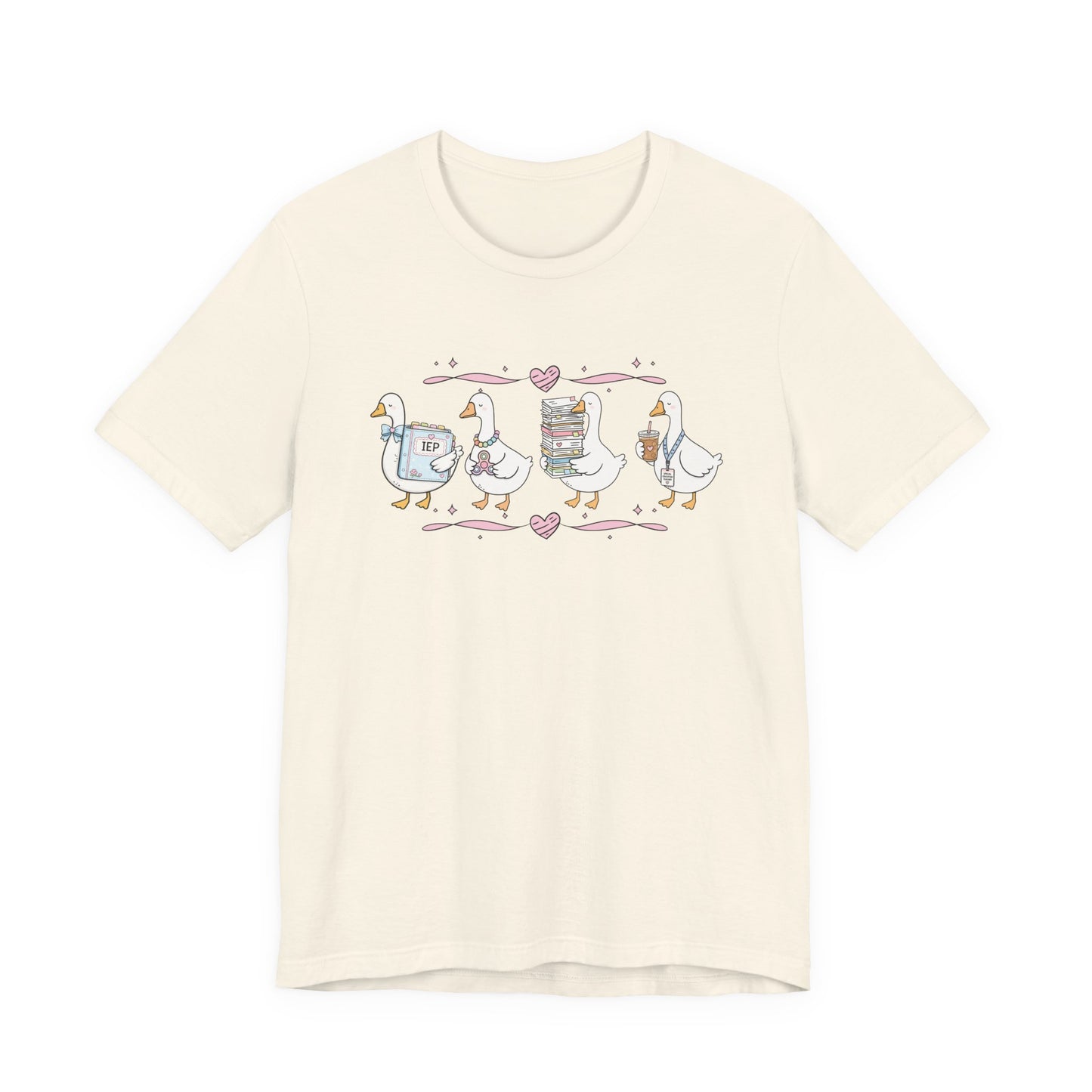 Bella + Canvas 3001 t-shirt in Natural featuring a coquette special education teacher goose design. Four white geese hold an IEP binder, sensory fidget toy, stack of paperwork, and iced coffee with a special education teacher lanyard. Pink hearts and ribbon accents add a sweet classroom-inspired touch. This cute SPED teacher shirt is perfect for special education teachers, back-to-school outfits, teacher appreciation gifts, and everyday classroom wear.