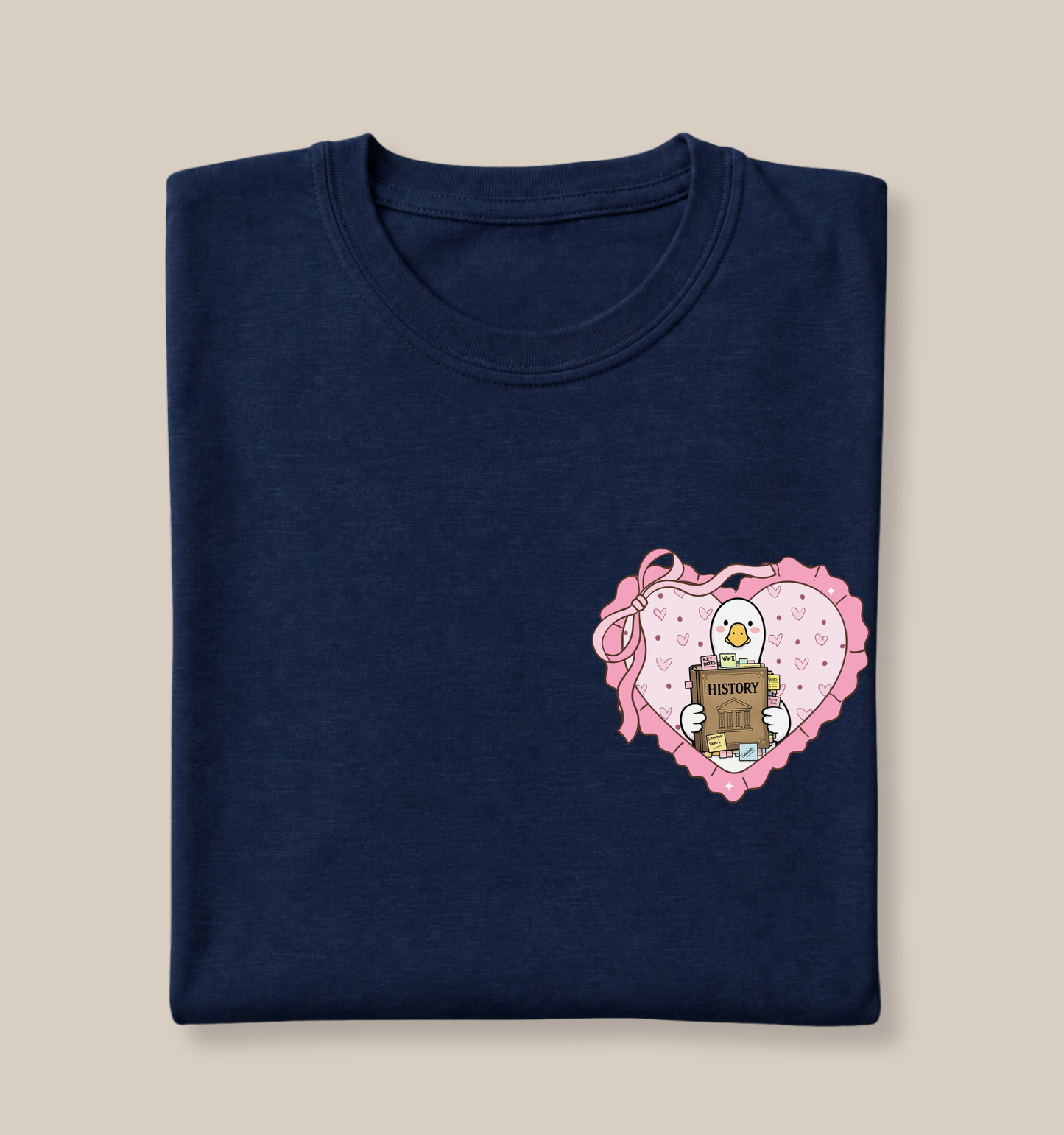 Bella + Canvas 3001 t-shirt in Navy featuring a coquette history teacher goose heart design on the left chest. The design shows a white goose holding a history book covered in study notes and tabs inside a pink heart with ribbon bow details. Perfect for history teachers, social studies educators, humanities teachers, teacher appreciation gifts, classroom wear, and back-to-school outfits.