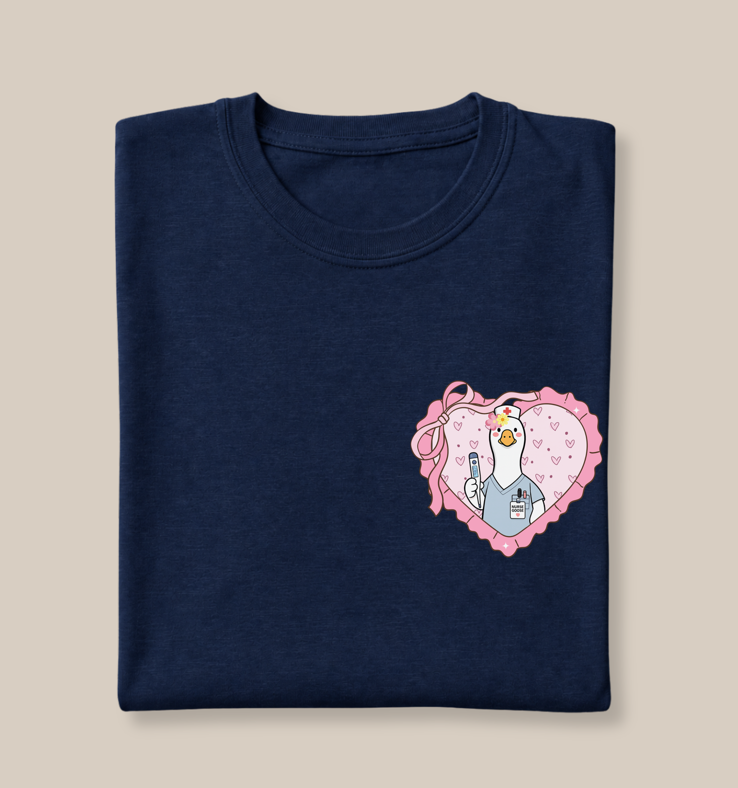 Bella + Canvas 3001 t-shirt in Navy featuring a coquette school nurse goose heart design on the left chest. The artwork shows a white goose dressed in nurse scrubs holding a thermometer inside a pink heart with ribbon bow accents and heart details. Perfect for school nurses, registered nurses, nurse appreciation gifts, healthcare workers, back-to-school staff apparel, and nursing professionals.