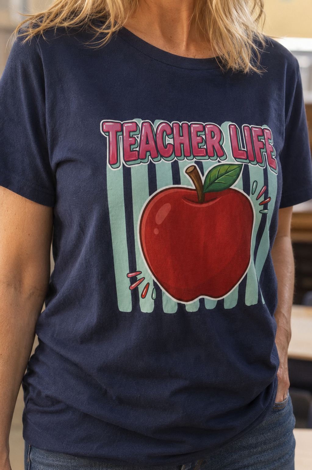 Bella + Canvas 3001 unisex t-shirt in Navy featuring a colorful "Teacher Life" graphic with a large red apple on a mint striped background. Comfortable teacher graphic tee perfect for educators, back-to-school, classroom wear, and everyday casual outfits.