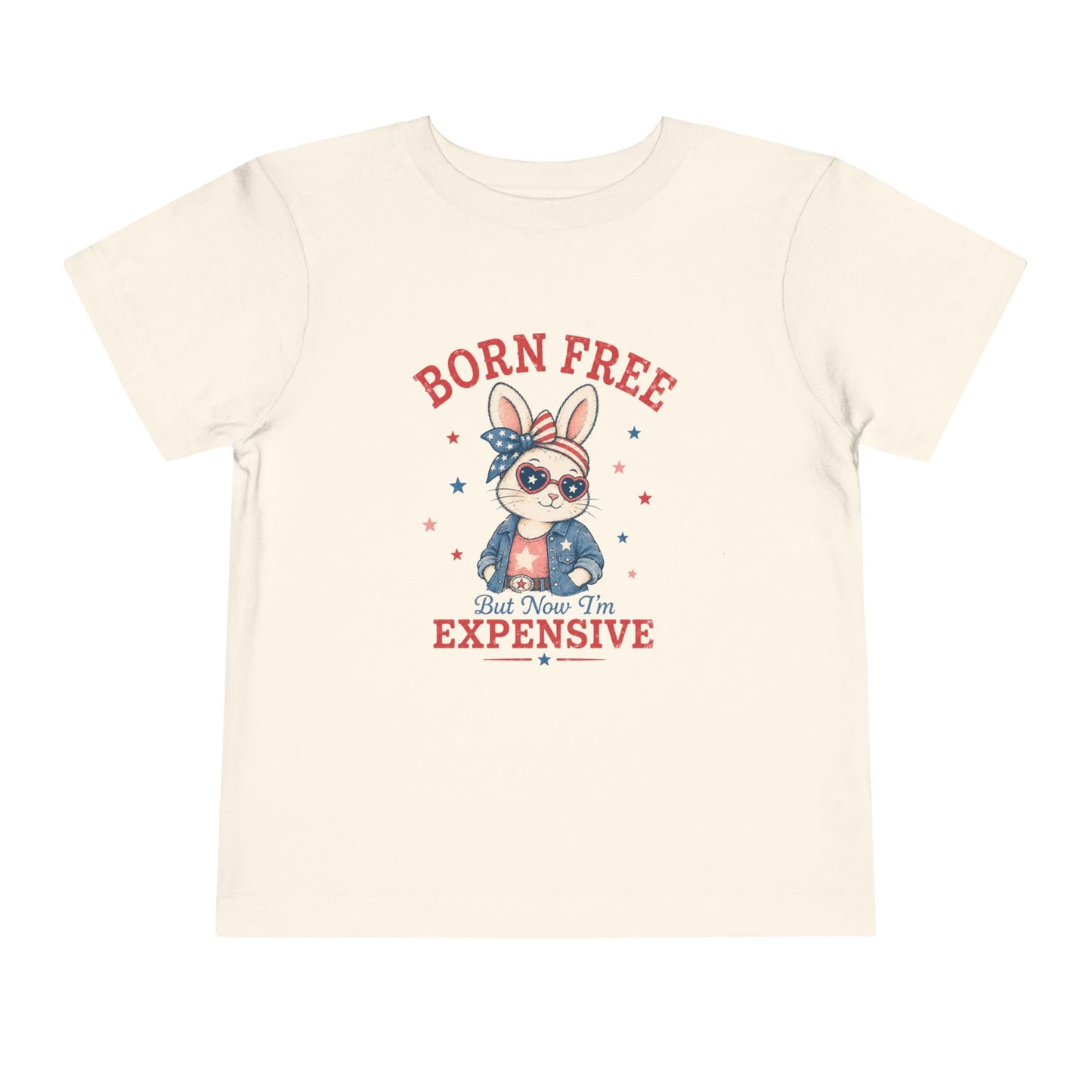 Bella + Canvas toddler natural colored t-shirt featuring a patriotic bunny graphic with heart sunglasses, stars and stripes bow, denim jacket, and the phrase “Born Free But Now I’m Expensive” in vintage red and blue lettering.