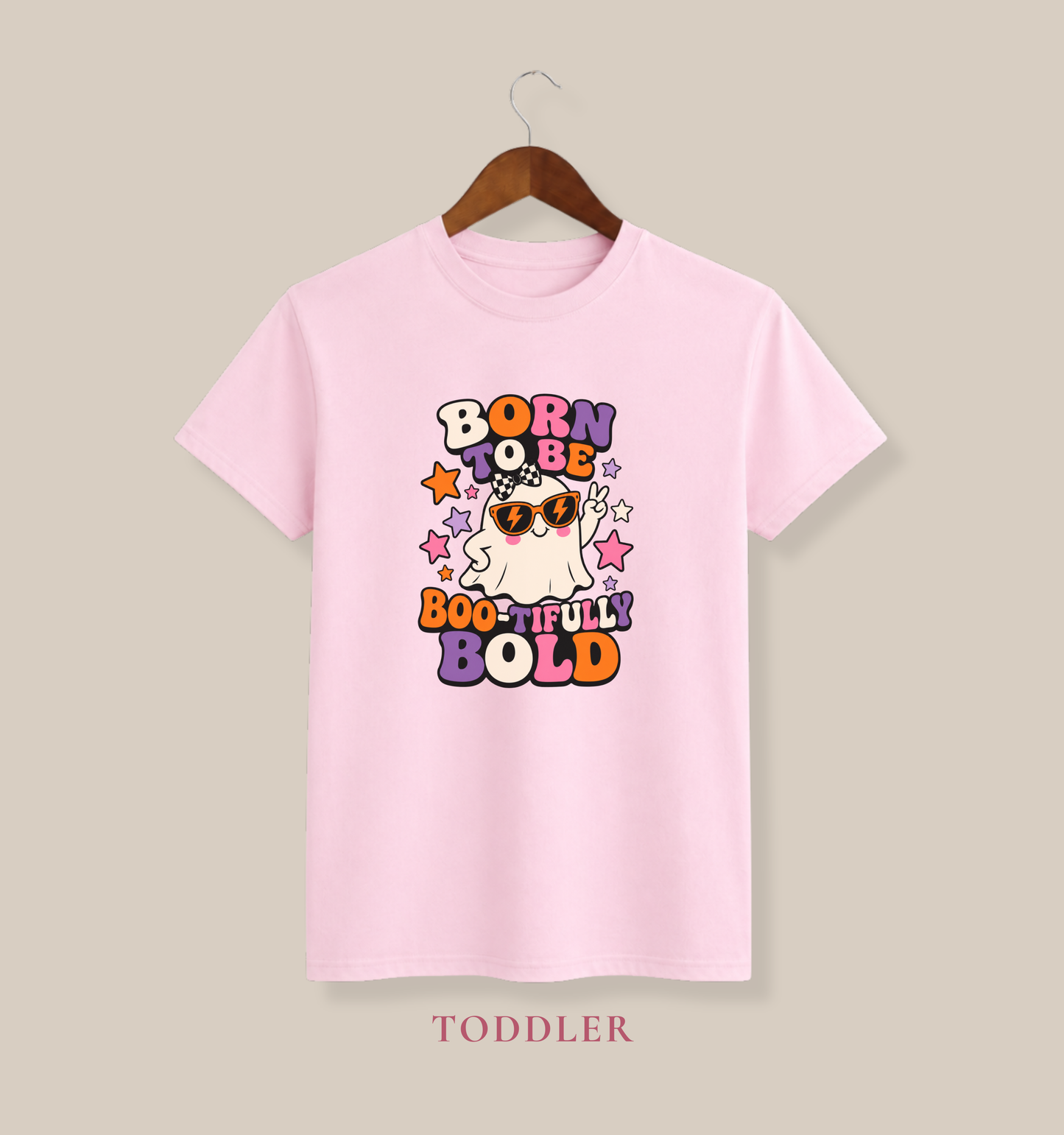 Pink youth T-shirt featuring a sunglasses-wearing ghost, colorful stars, and the phrase “Born to Be Boo-tifully Bold.”