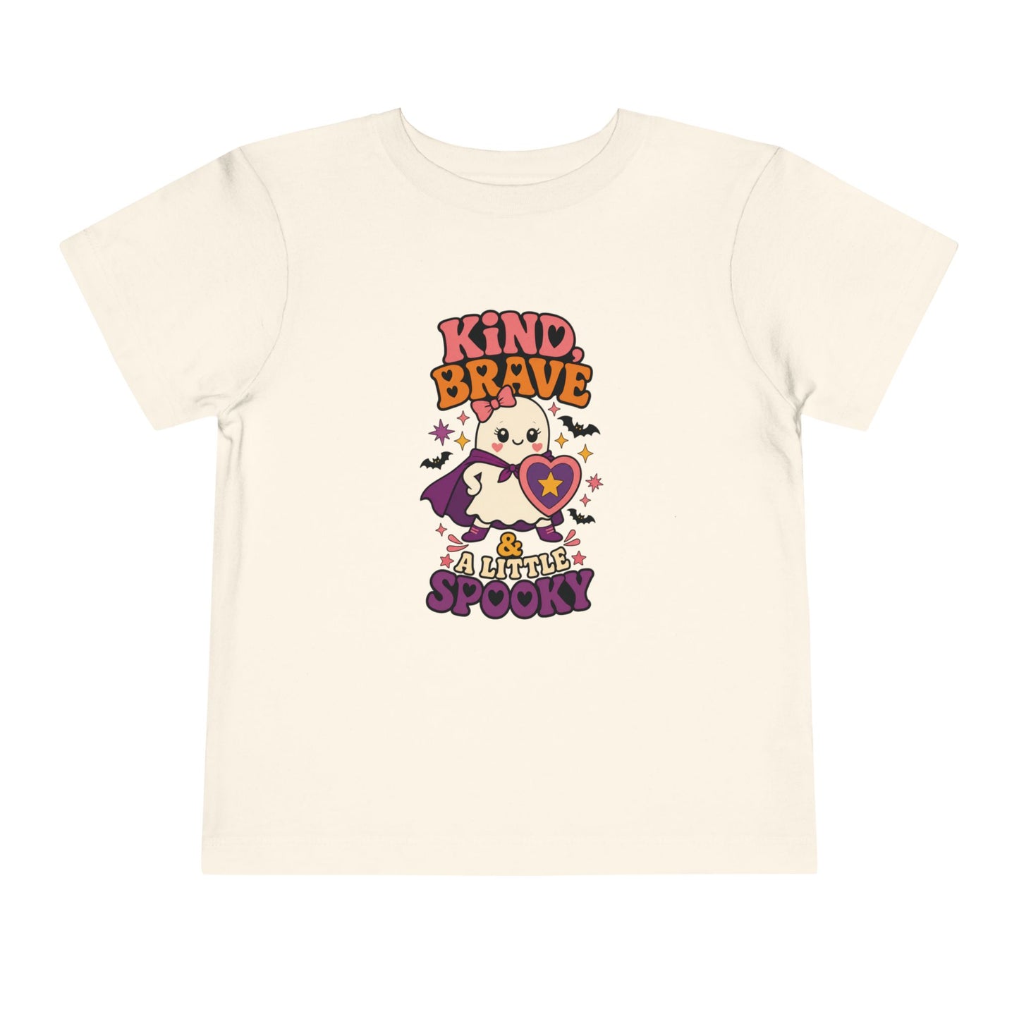 Natural toddler T-shirt featuring a caped ghost with a heart shield and the phrase “Kind, Brave & a Little Spooky.”