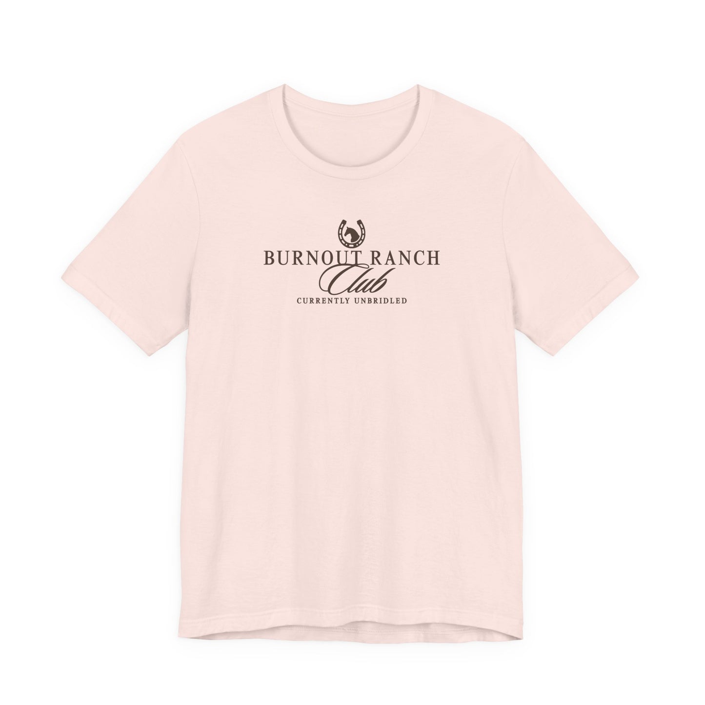 Soft pink Bella + Canvas 3001 t-shirt featuring a western-inspired “Burnout Ranch Club” graphic with “Currently Unbridled” text in dark brown lettering.