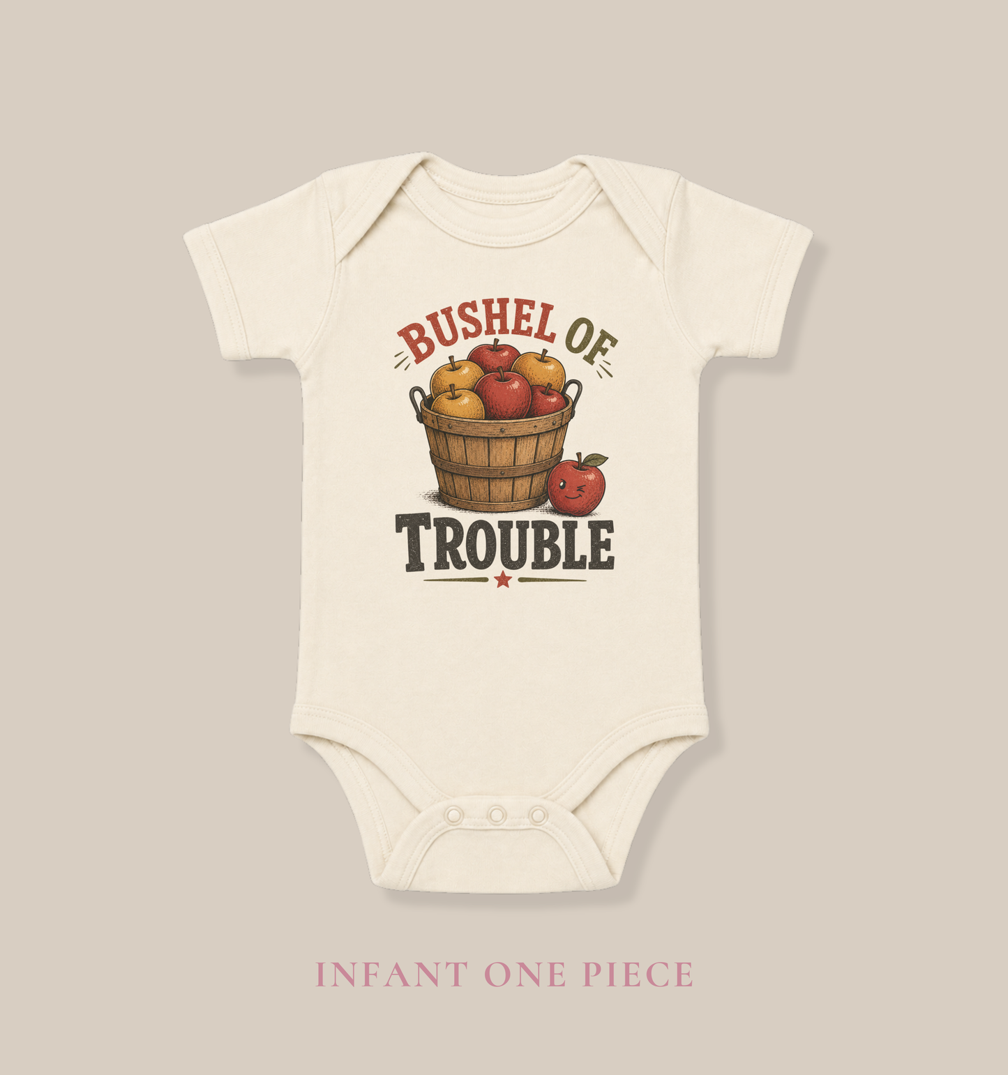Natural baby one piece featuring a vintage basket of apples and the playful phrase “Bushel of Trouble.”