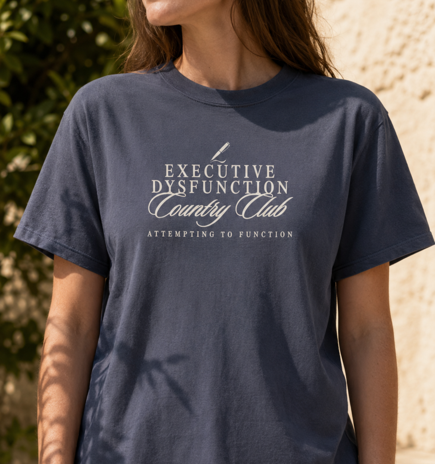 CC1717 garment-dyed t-shirt in True Navy featuring the "Executive Dysfunction Country Club" graphic with a pen icon and the phrase "Attempting to Function." A funny neurodivergent-inspired graphic tee perfect for ADHD awareness, mental health humor, students, teachers, office workers, and anyone who appreciates relatable sarcastic apparel.