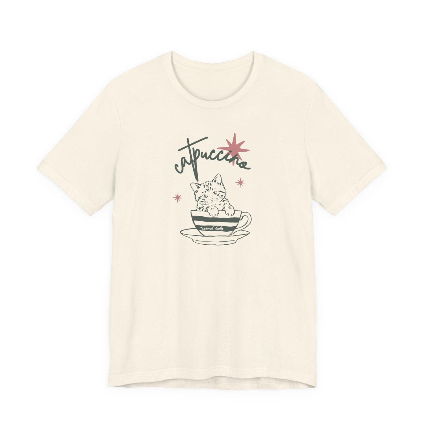 Natural Bella + Canvas 3001 t-shirt featuring a minimalist “Catuccine” cat coffee graphic with a kitten sitting inside a coffee cup and retro-inspired lettering in muted pink and green tones.
