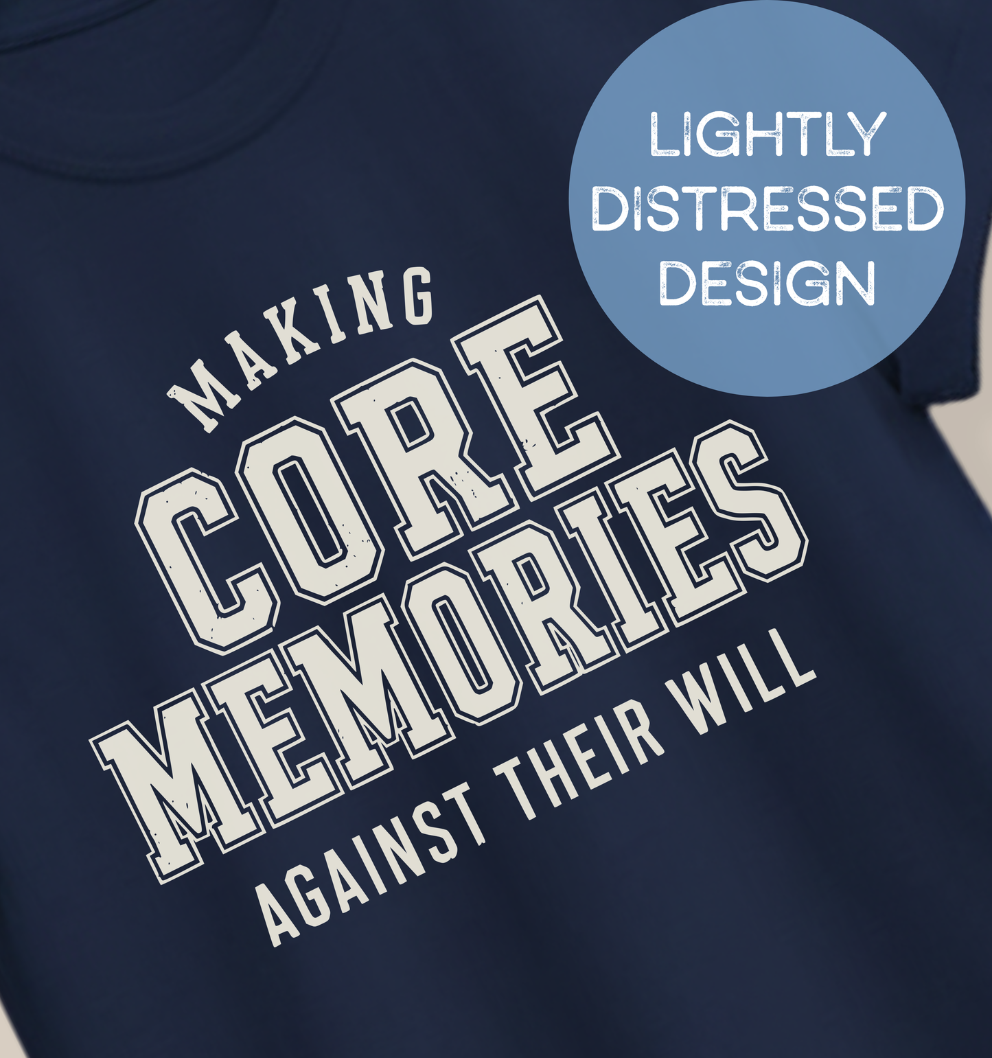 Close-up of a navy adult T-shirt featuring lightly distressed cream varsity lettering and the humorous phrase “Making Core Memories Against Their Will.”