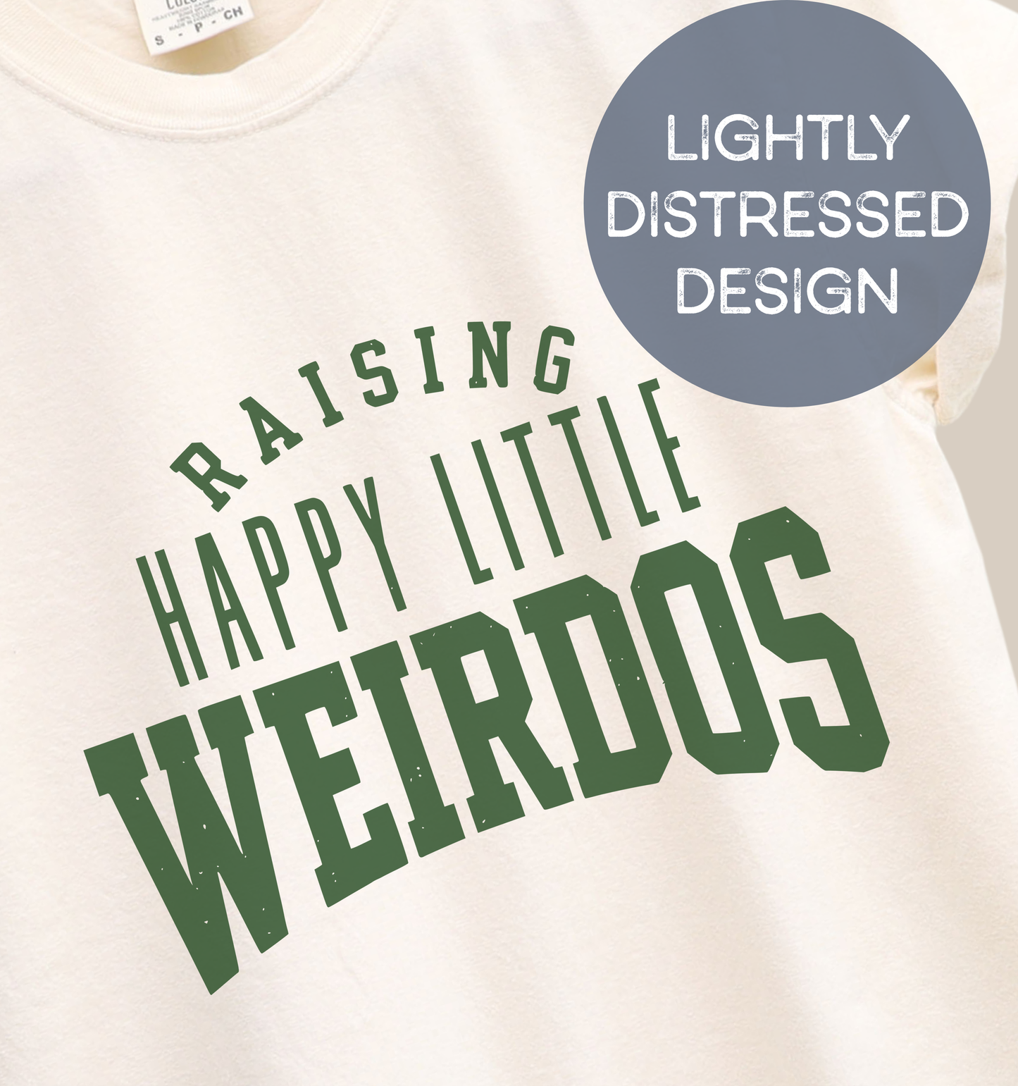 Close-up of a natural adult T-shirt featuring lightly distressed dark green varsity lettering and the playful phrase “Raising Happy Little Weirdos.”