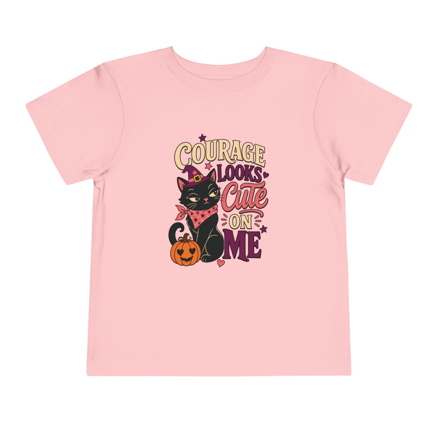Pink toddler T-shirt featuring a witchy black cat, smiling jack-o’-lantern, colorful stars, and the phrase “Courage Looks Cute on Me.”