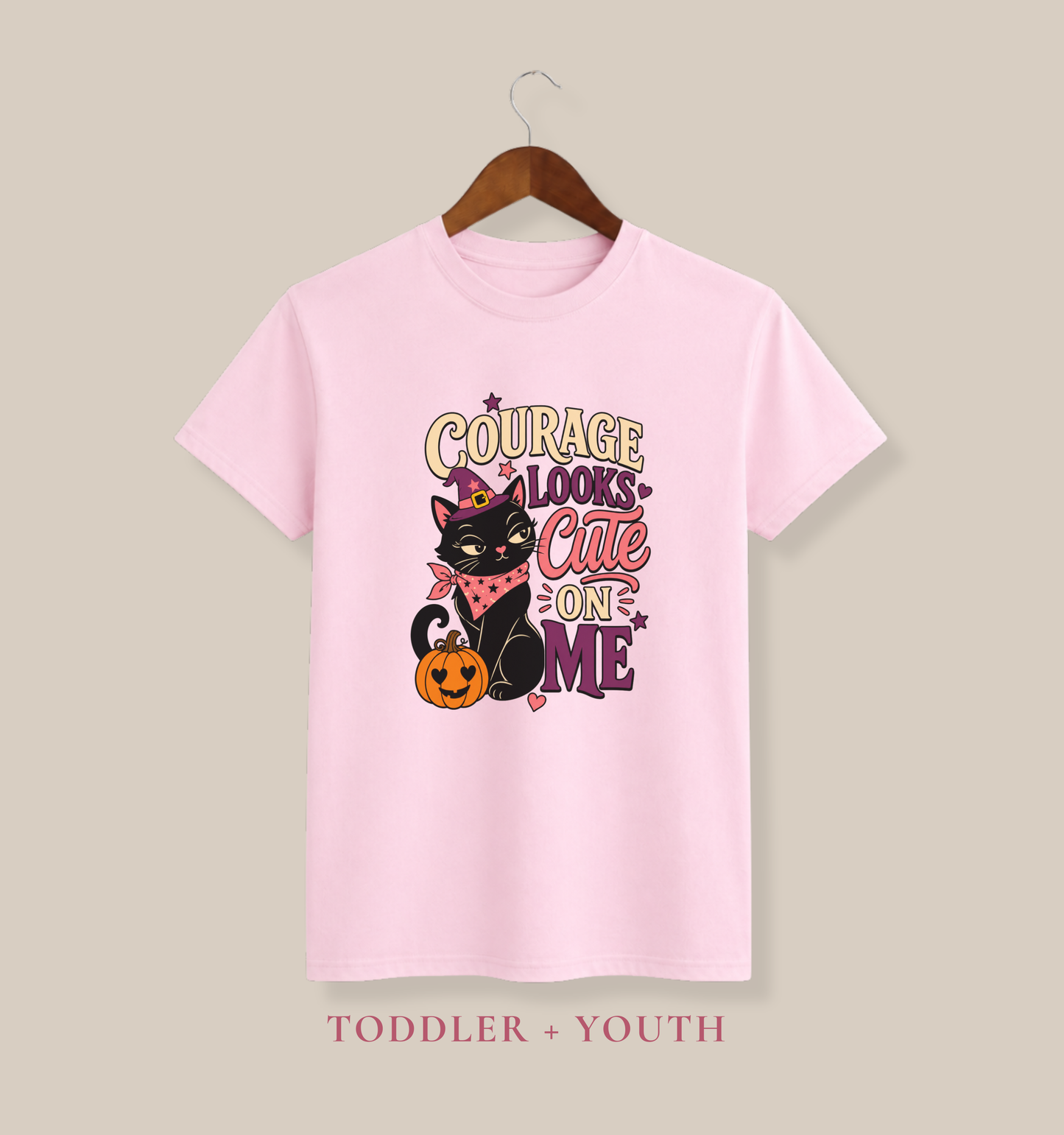 Pink color youth T-shirt featuring a confident black cat in a purple witch hat, a smiling pumpkin, hearts, and colorful Halloween lettering.