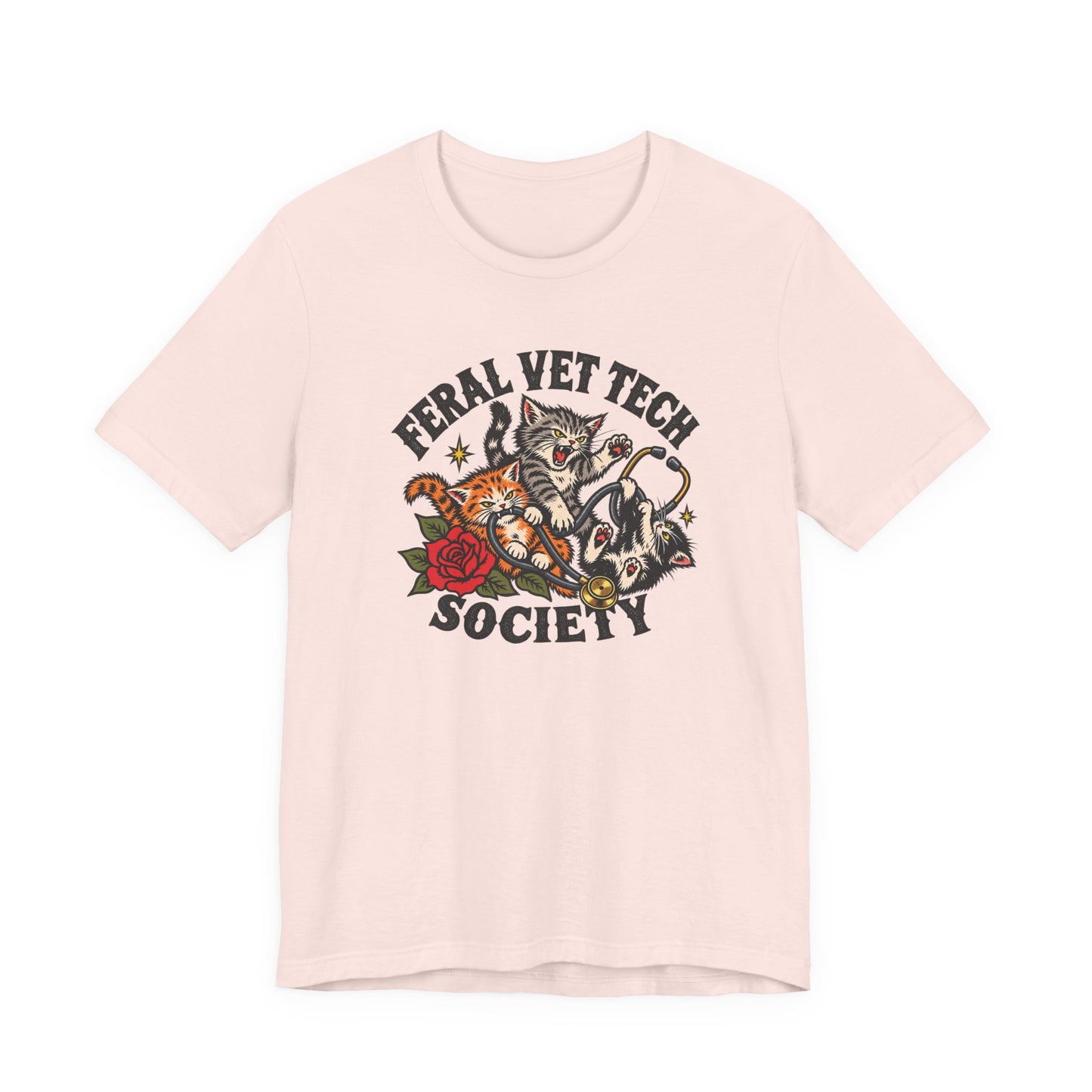 Soft pink classic fit tee displaying a Feral Vet Tech Society design with illustrated cats, a gold stethoscope, red rose, and vintage-style lettering.