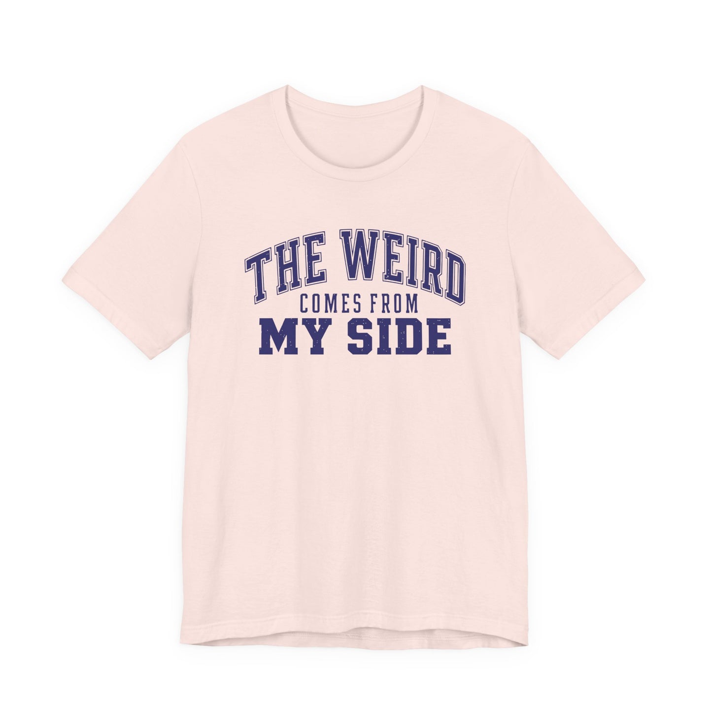 Soft pink adult T-shirt featuring bold collegiate lettering and the playful phrase “The Weird Comes From My Side.”