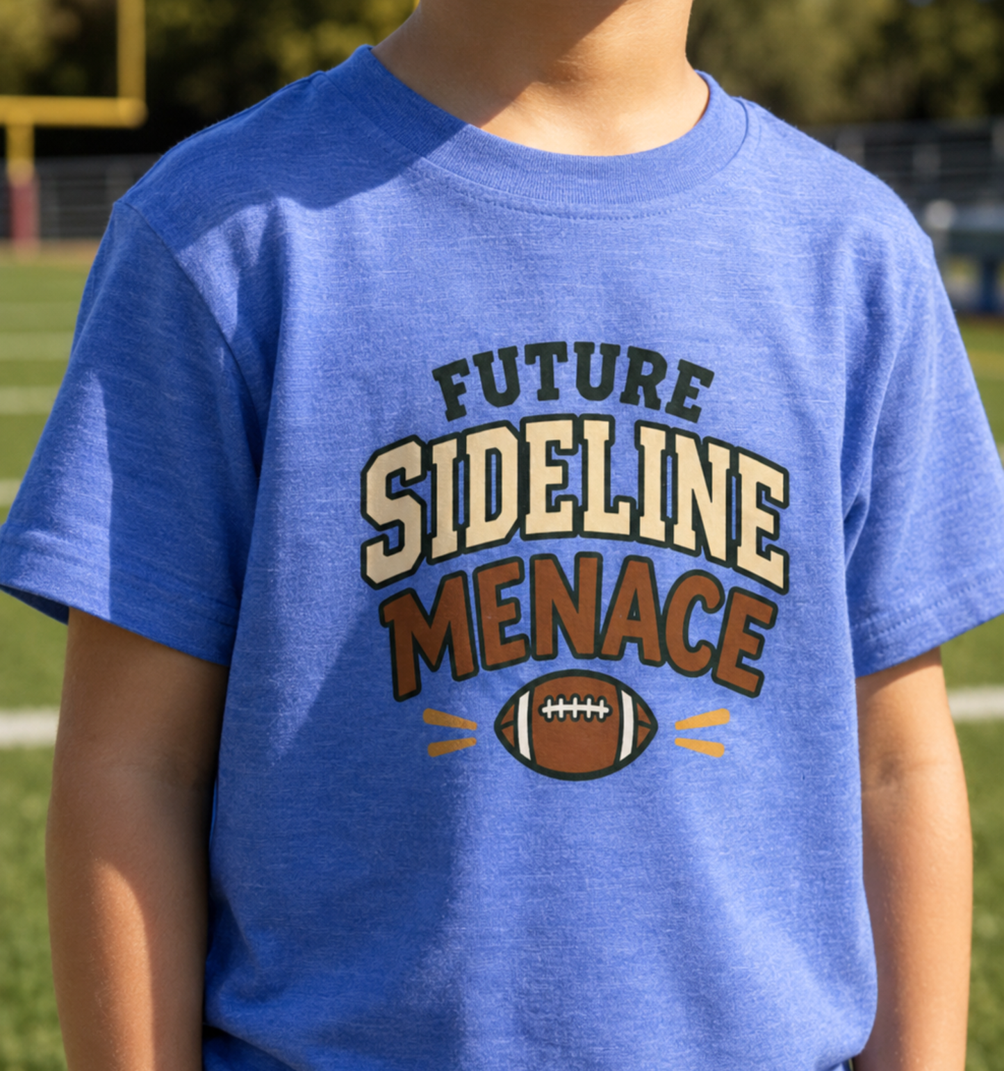 Child wearing a heather Columbia blue toddler T-shirt featuring a football graphic and the playful phrase “Future Sideline Menace.”