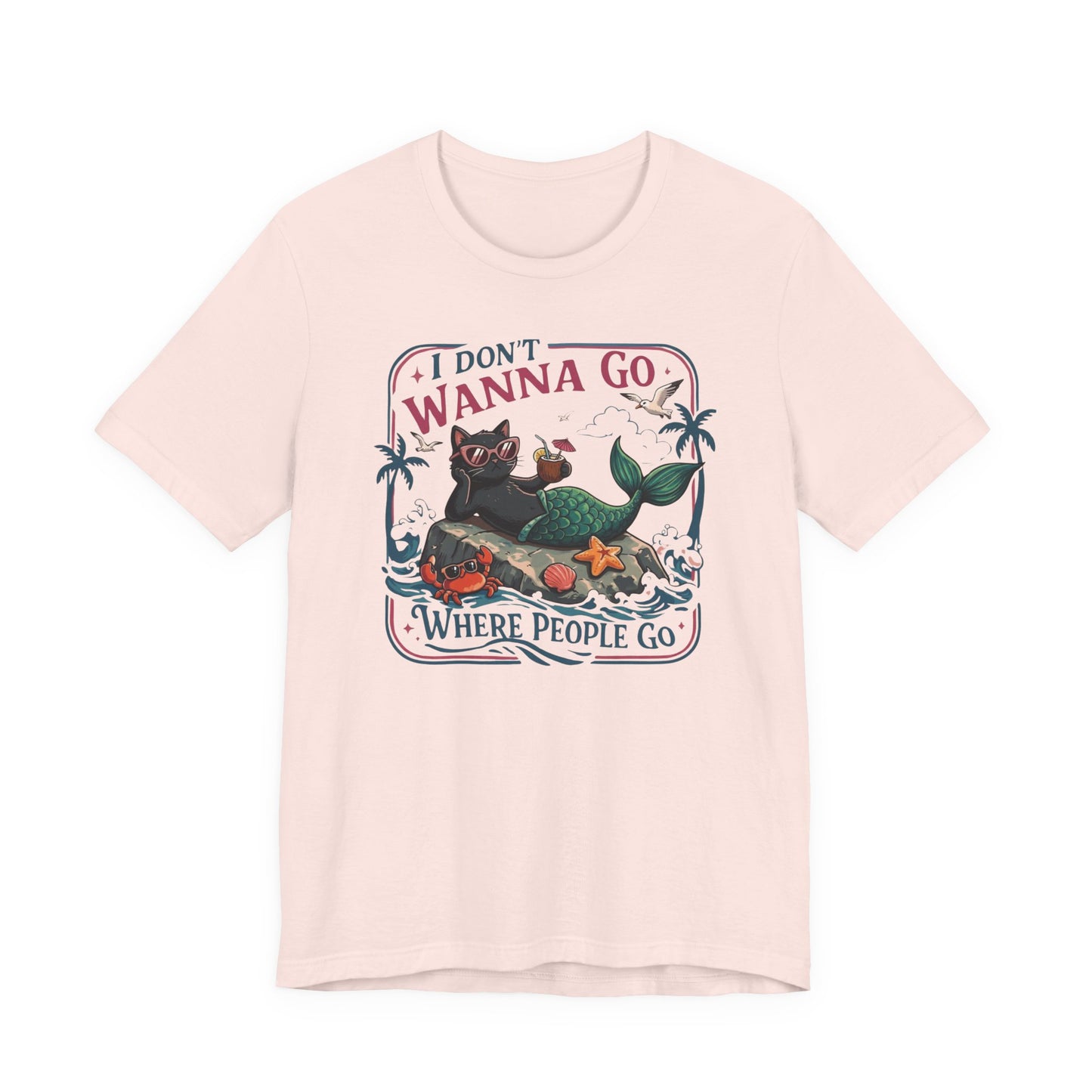 Bella + Canvas 3001 t-shirt in soft pink featuring a funny introvert-inspired black cat mermaid graphic with sunglasses, tropical beach details, and the phrase “I Don’t Wanna Go Where People Go.”