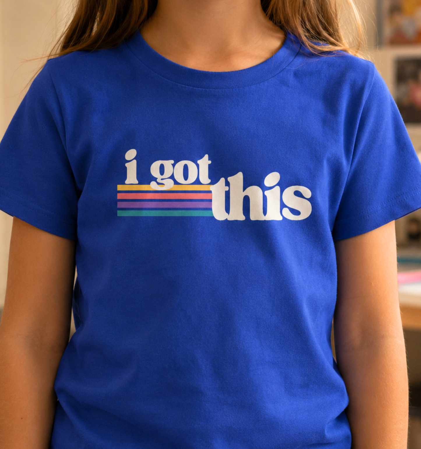Child wearing a true royal blue toddler T-shirt featuring the motivational phrase “I Got This” with colorful retro stripes.