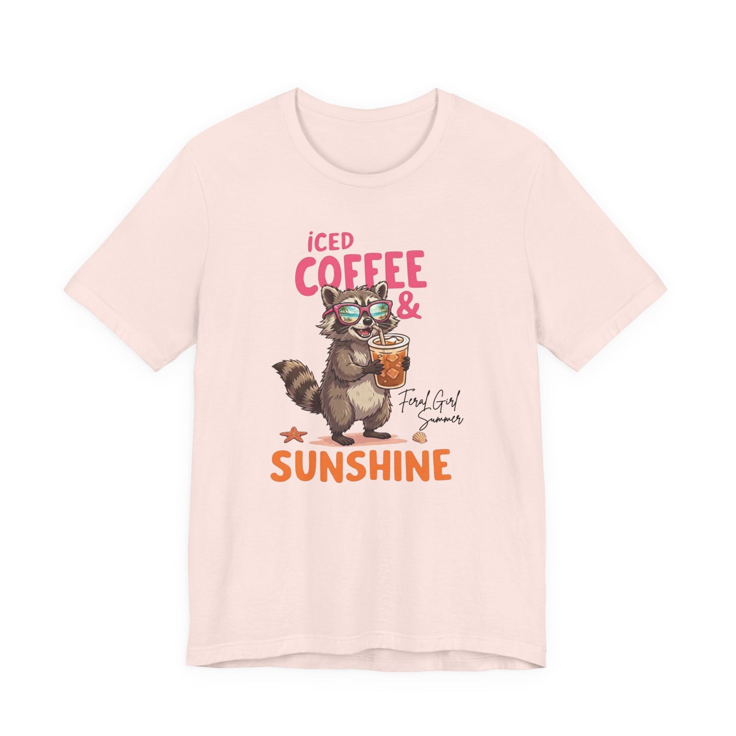 Bella + Canvas 3001 t-shirt in soft pink featuring a raccoon wearing sunglasses and holding an iced coffee with the phrase “Iced Coffee & Sunshine” in colorful summer-inspired lettering.