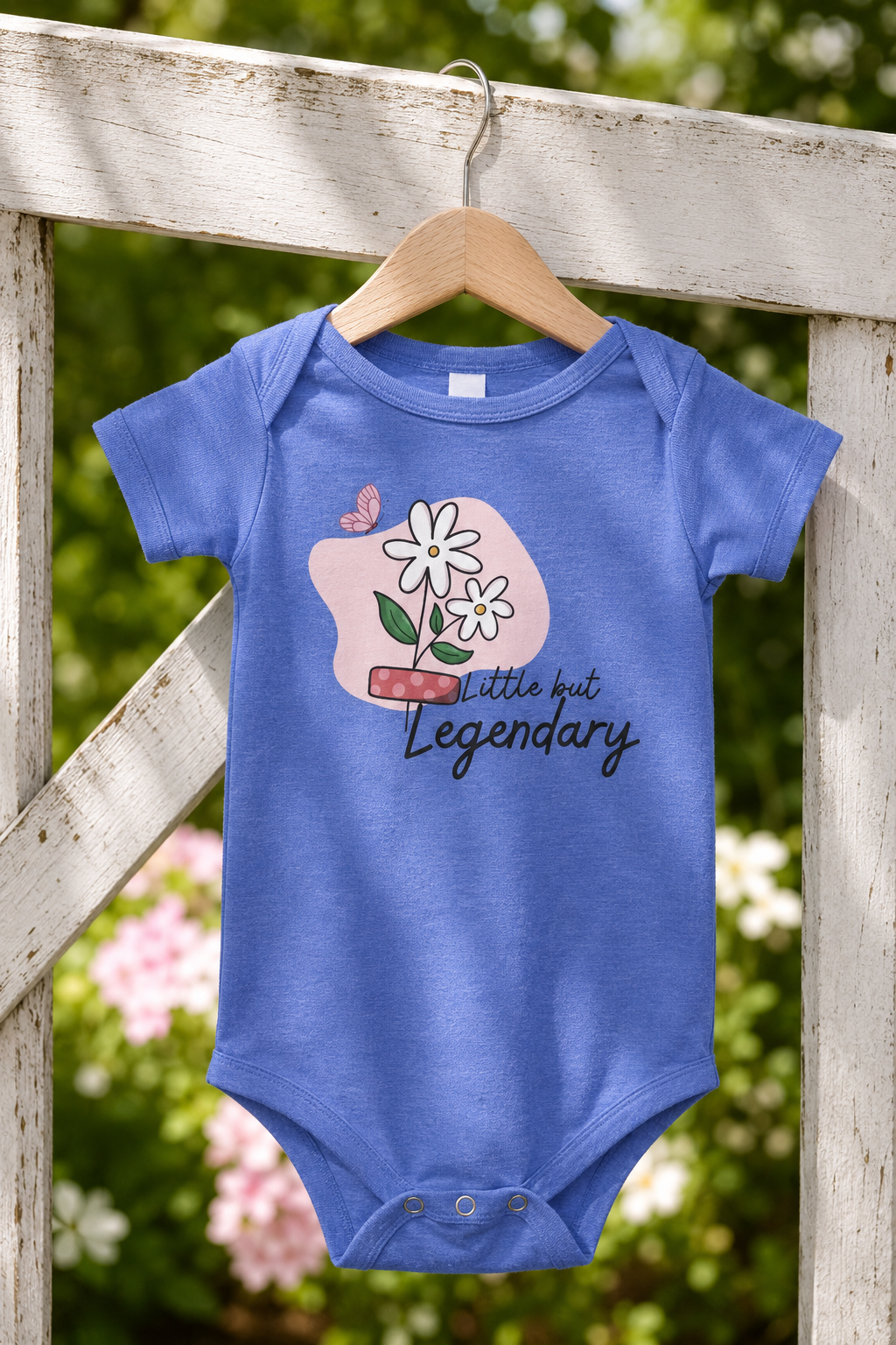 True royal blue baby one piece featuring white daisies, a pink butterfly, and the empowering phrase “Little but Legendary.”