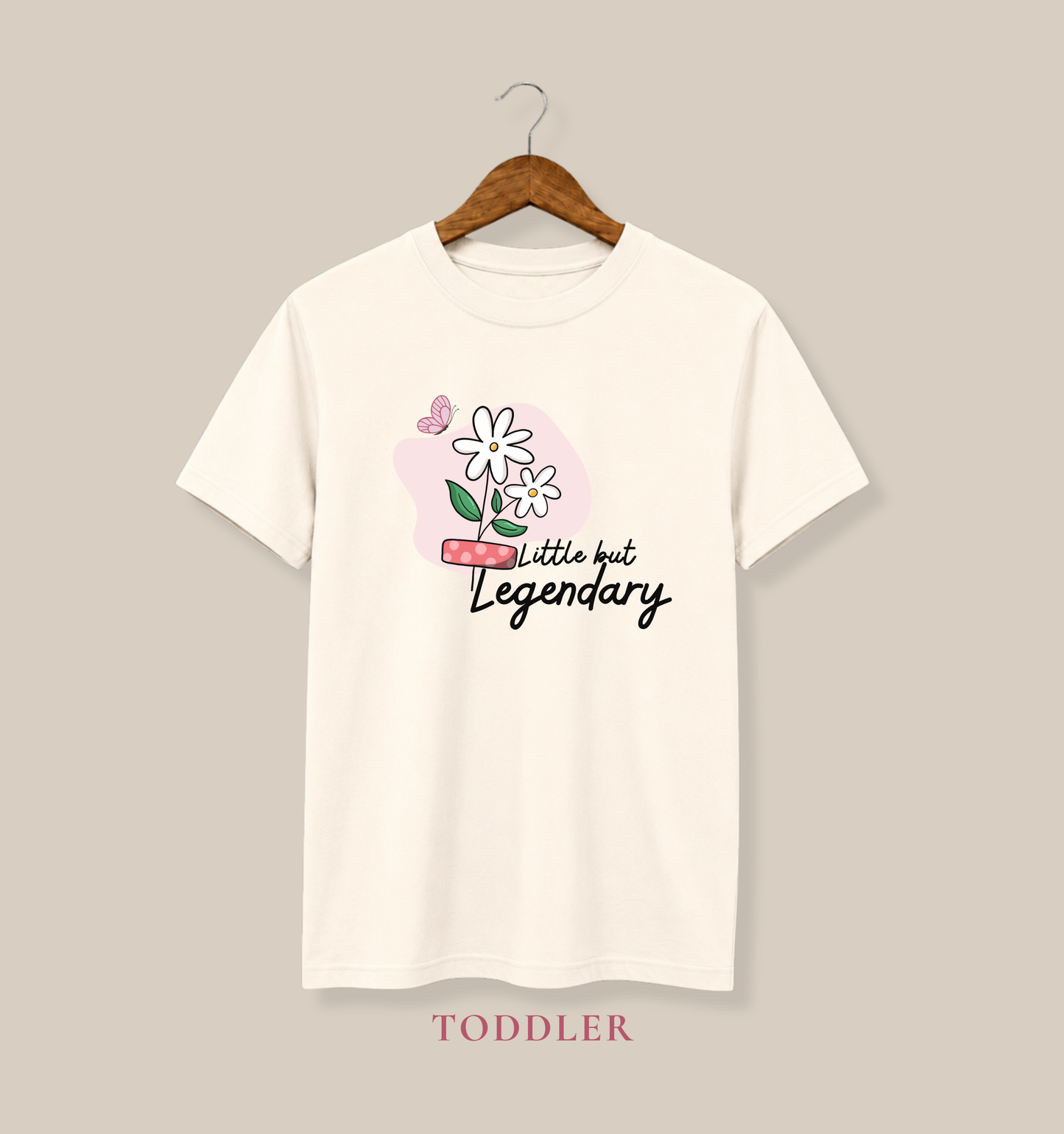Natural color toddler T-shirt featuring daisies, a pink bandage, a butterfly, and the phrase “Little but Legendary.”