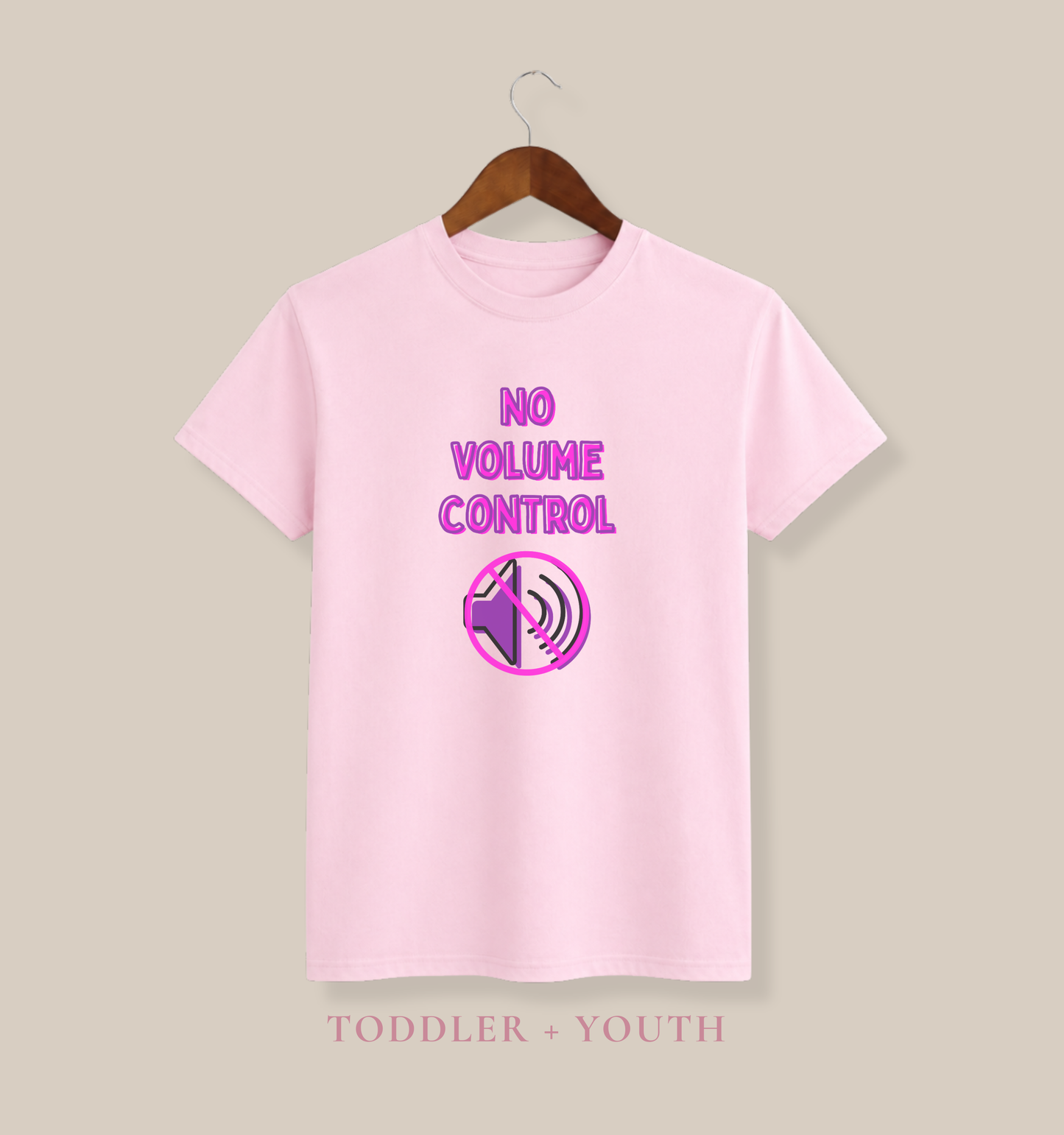 A light pink short-sleeve t-shirt hanging on a wooden hanger against a solid beige background. The shirt features a graphic on the chest with the text 'NO VOLUME CONTROL' in pink and purple, accompanied by a speaker icon.