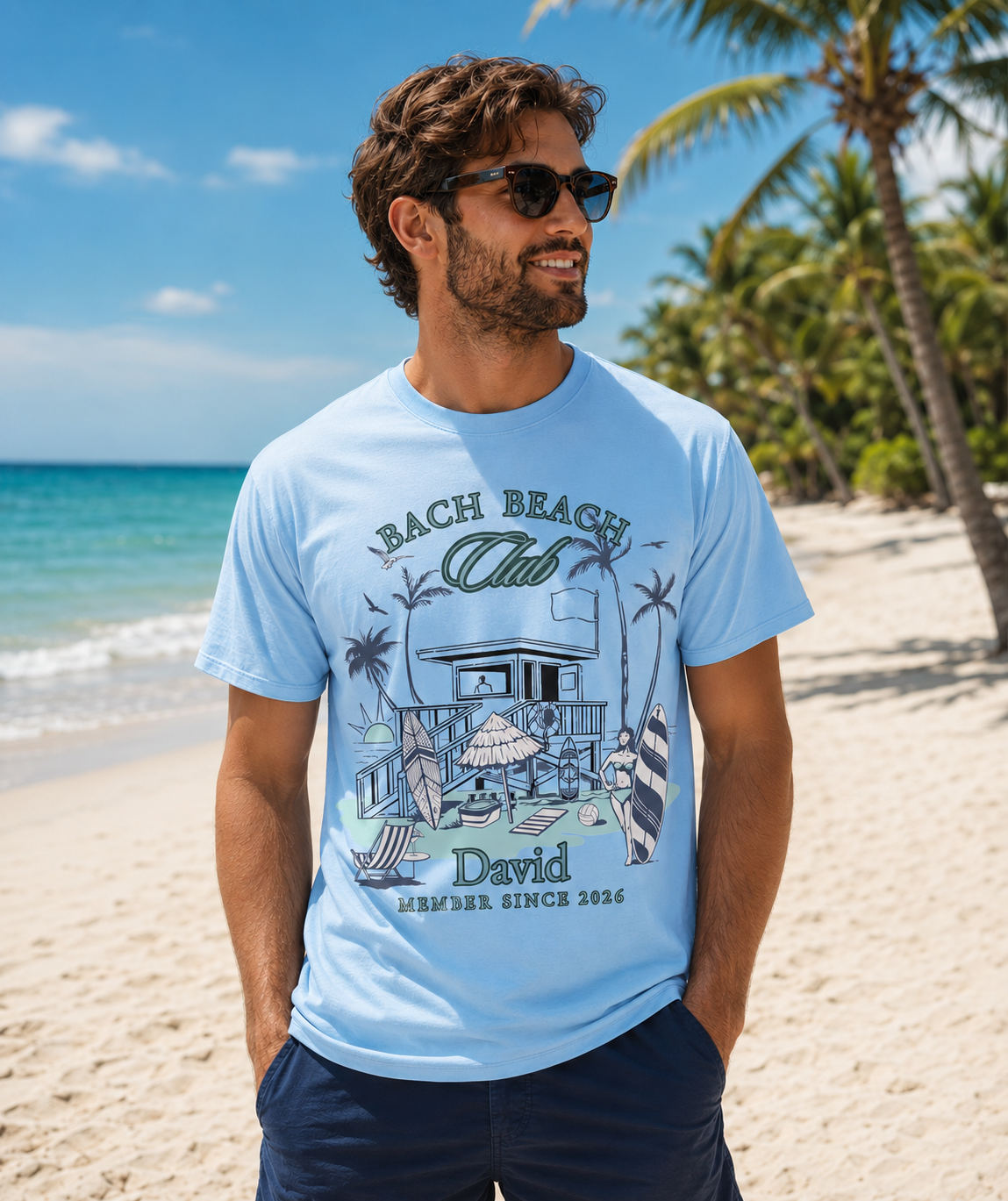 Man wearing a personalized Bella + Canvas 3001 t-shirt in baby blue featuring a retro beach bachelor party design with palm trees, surfboards, beach house artwork, custom name text, and “Bach Beach Club Member Since 2026” wording in coastal green and blue lettering.